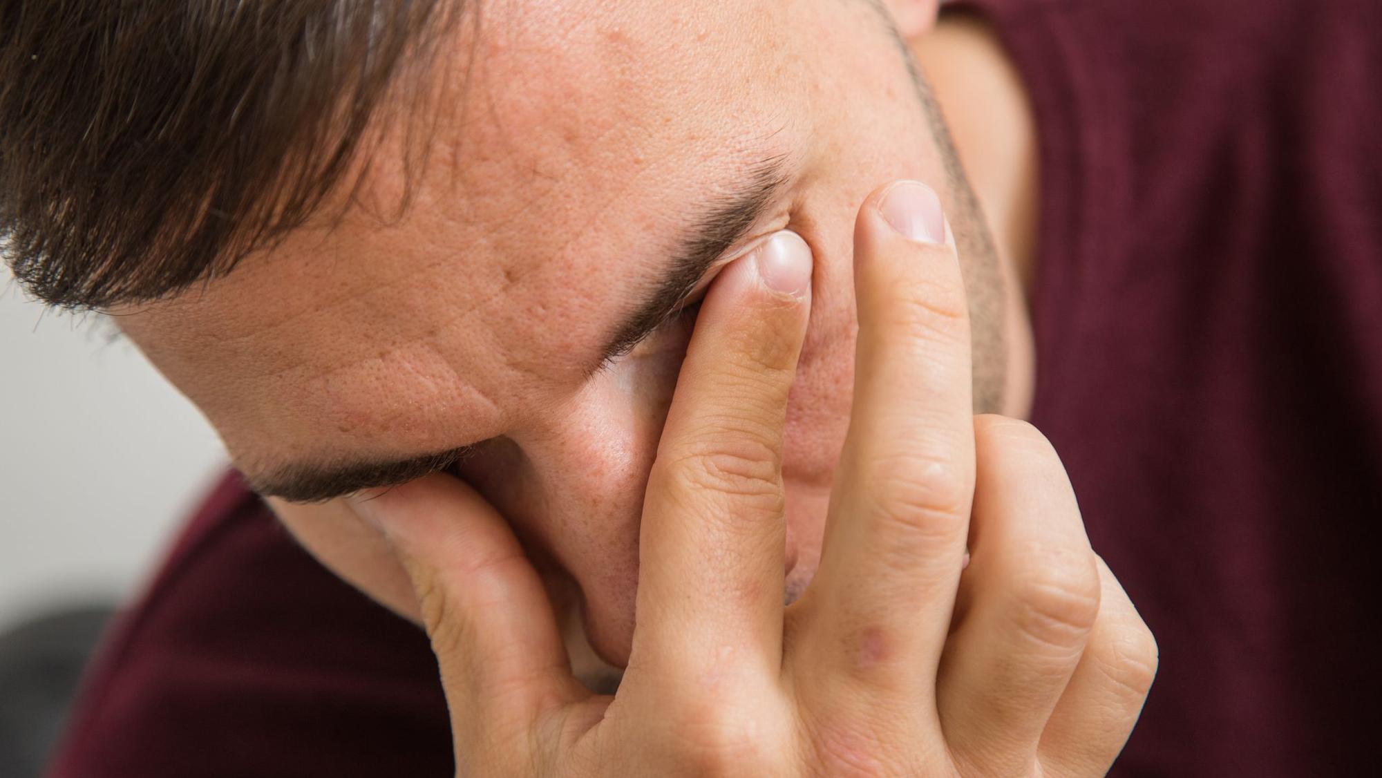 Mann fässt sich an die Augen