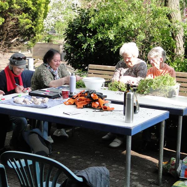 Eine Gruppe Senioren an einem Tisch bei Gartenarbeit. Nicolin Gabrysch (rechts) übernimmt die Leitung des Gartenprojekts.