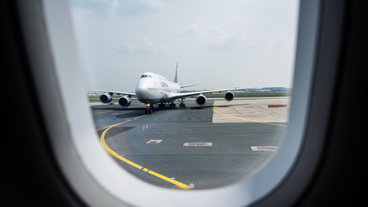Blick aus einem Flugzeug auf die Rollbahn am Flughafen