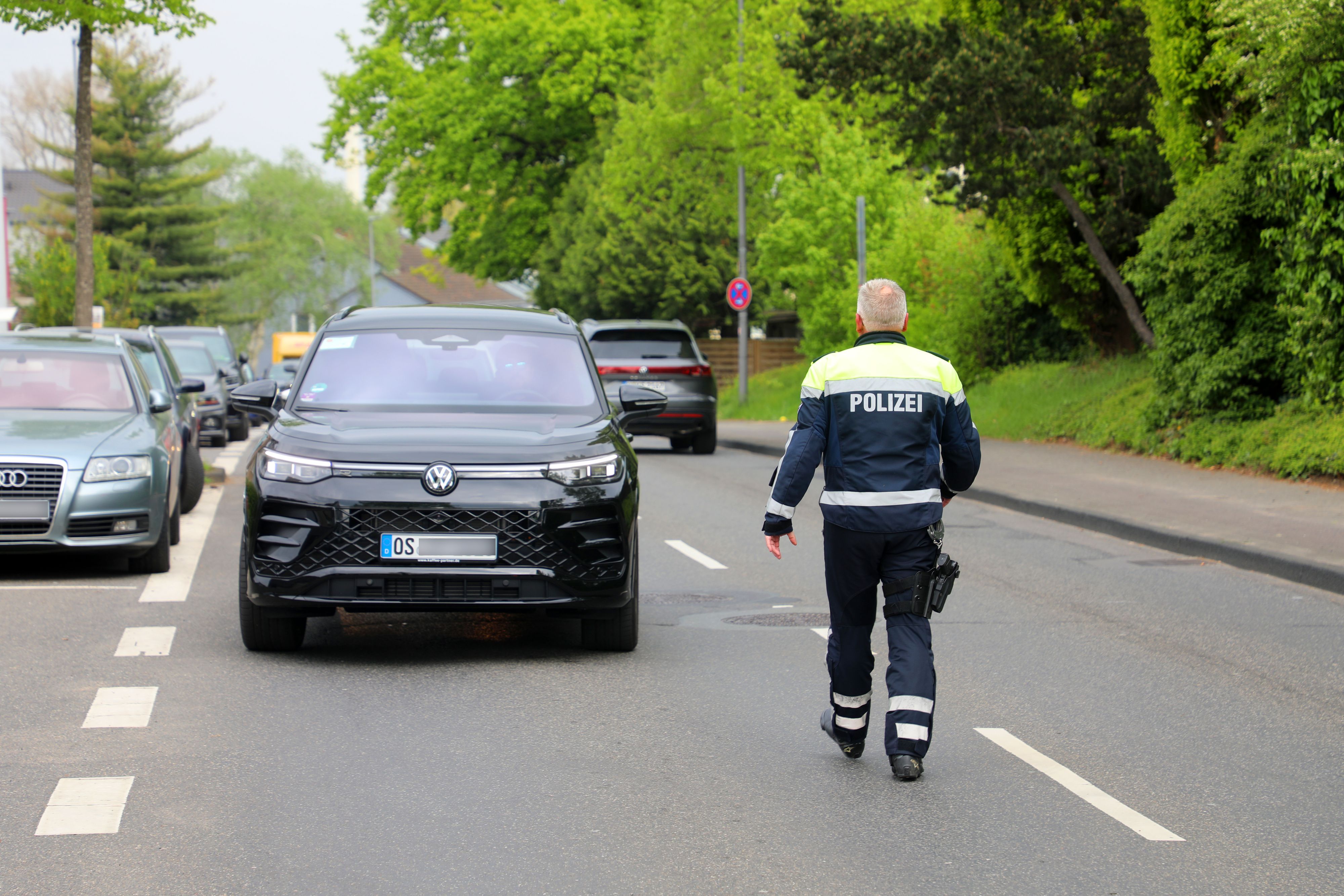 Ein Polizist geht auf ein angehaltenes Auto zu.