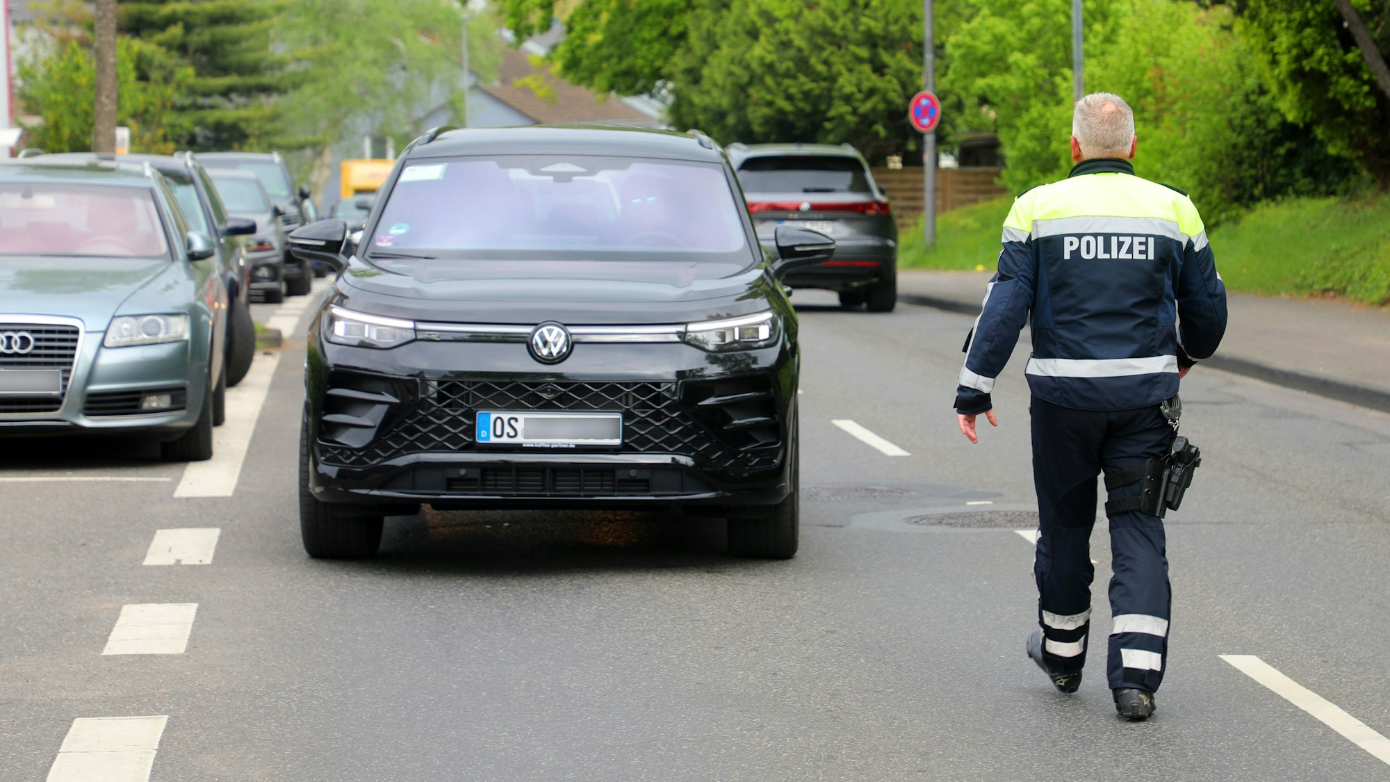 Ein Polizist geht auf ein angehaltenes Auto zu.