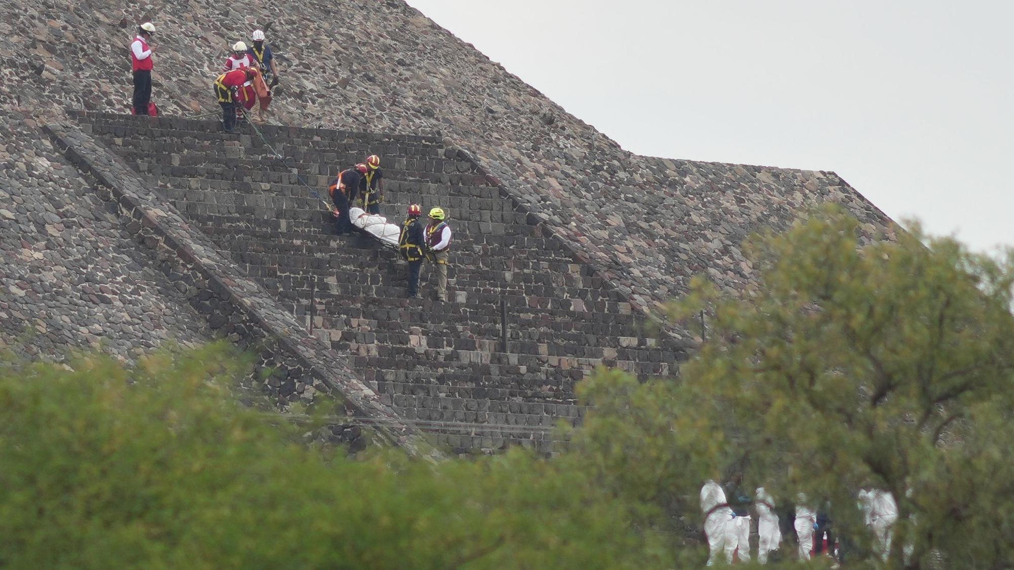 20.04.2026, Mexiko, Teotihuacan: Gerichtsmediziner tragen die Leiche eines Opfers eine Pyramide hinunter, nachdem ein Bewaffneter laut Behörden das Feuer eröffnet hat. Foto: Eduardo Verdugo/AP/dpa +++ dpa-Bildfunk +++