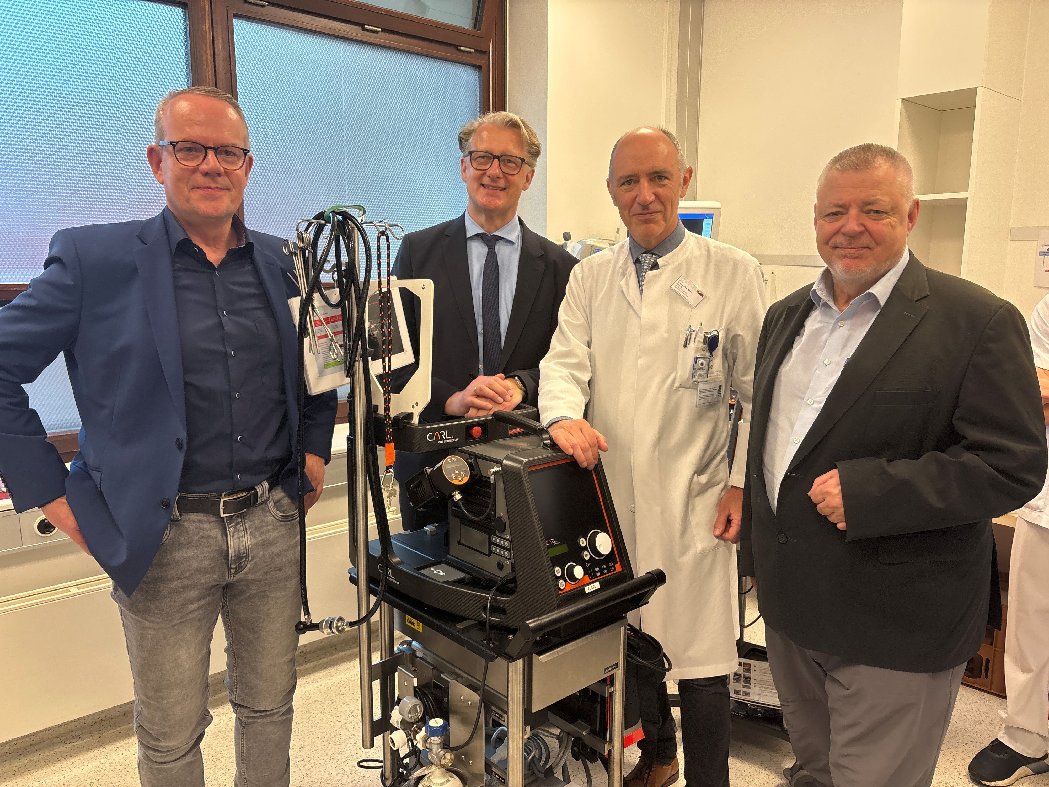 Die Kardiologie-Chefärzte Axel Meissner (Merheim), Marc Horlitz (Porz) und Frank Eberhardt (Kalk) sowie Alex Lechleuthner (von links), der Chef des Kölner Rettungsdienstes, mit einem Ecmo-Gerät im Evangelischen Krankenhaus Köln Kalk.