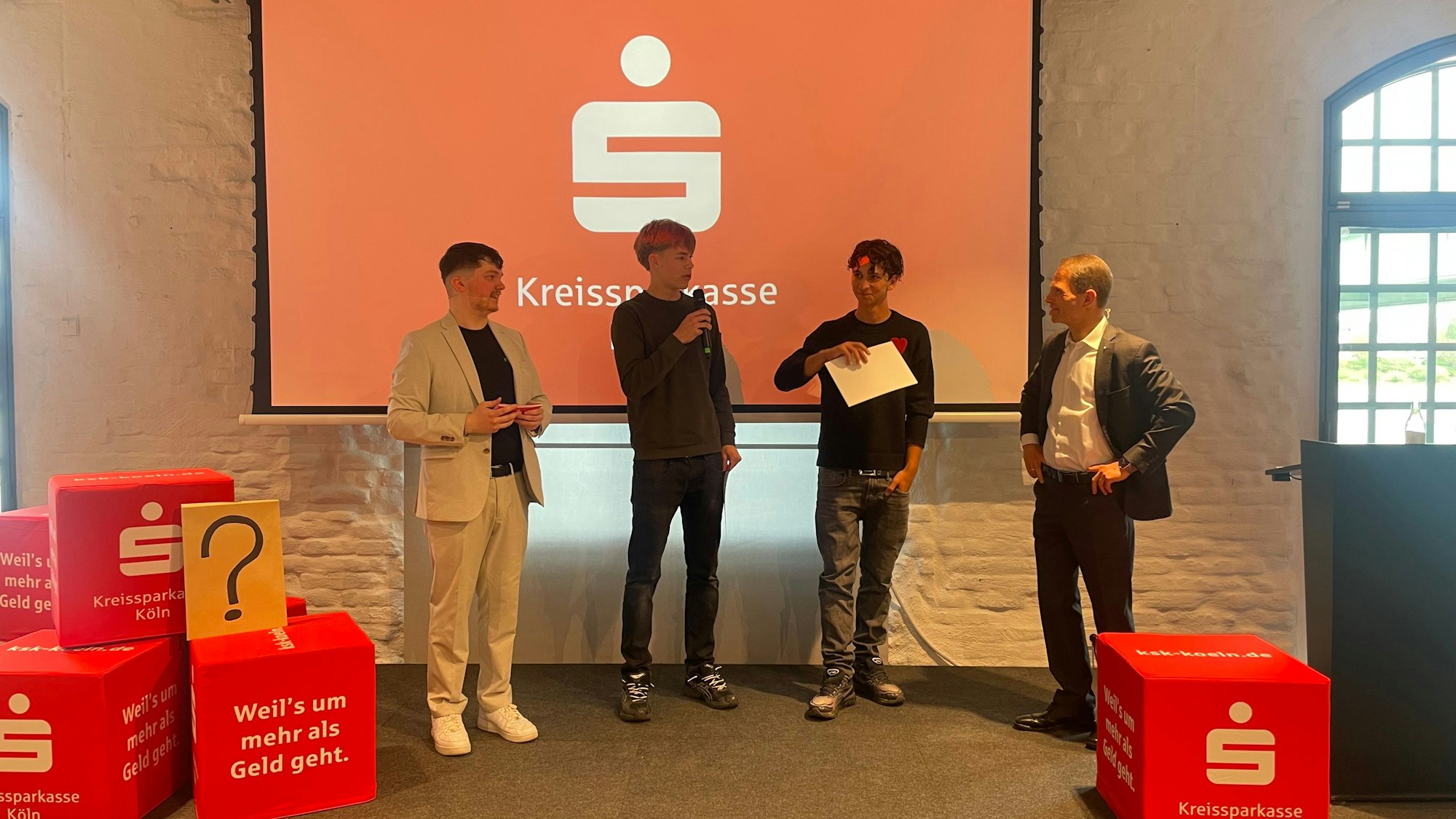 Männer stehen auf einer Bühne.