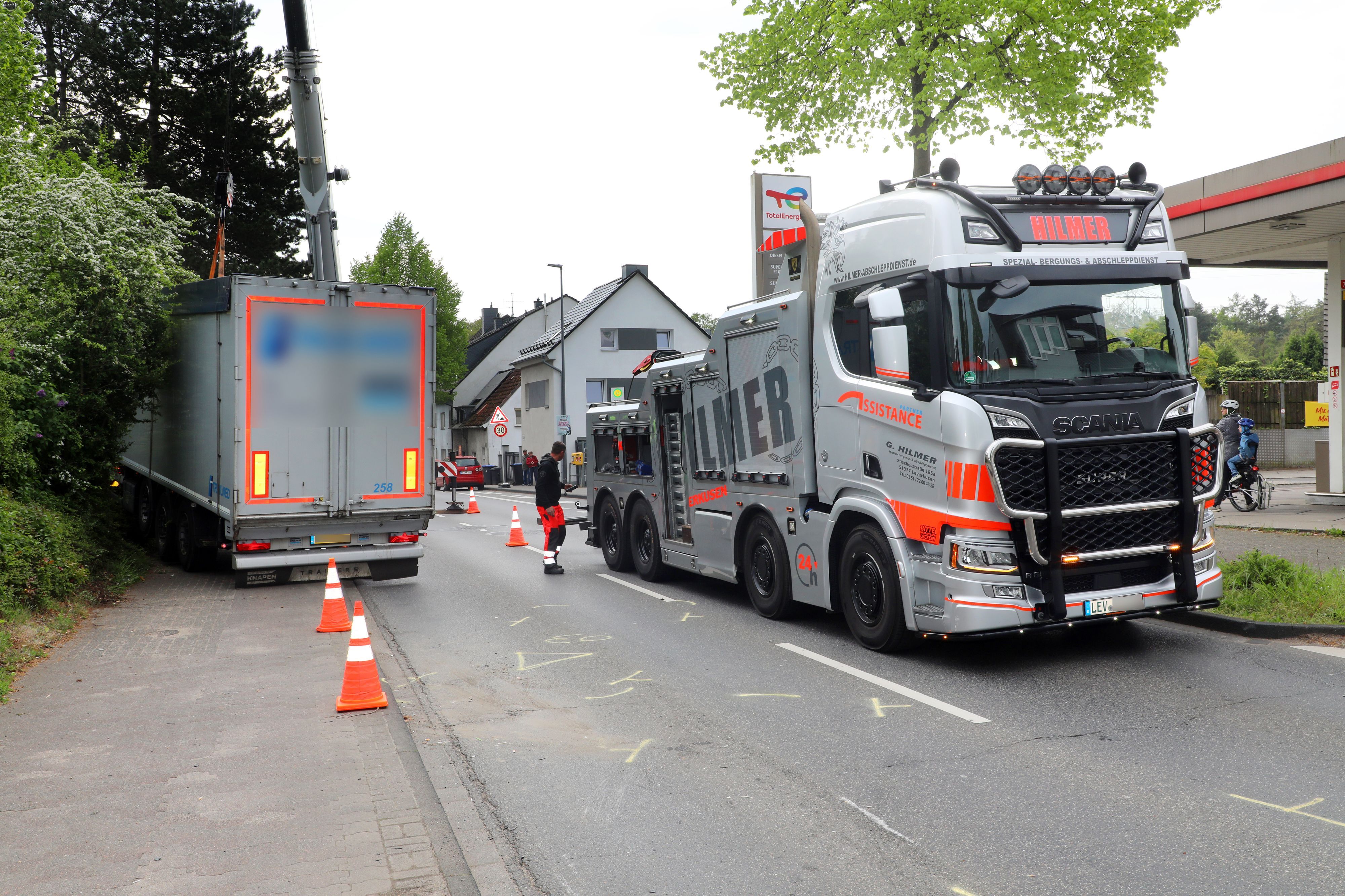 Ein Abschleppfahrzeug steht neben einem verunfallten Lkw auf der Bensberger Straße in Bergisch Gladbach-Heidkamp.