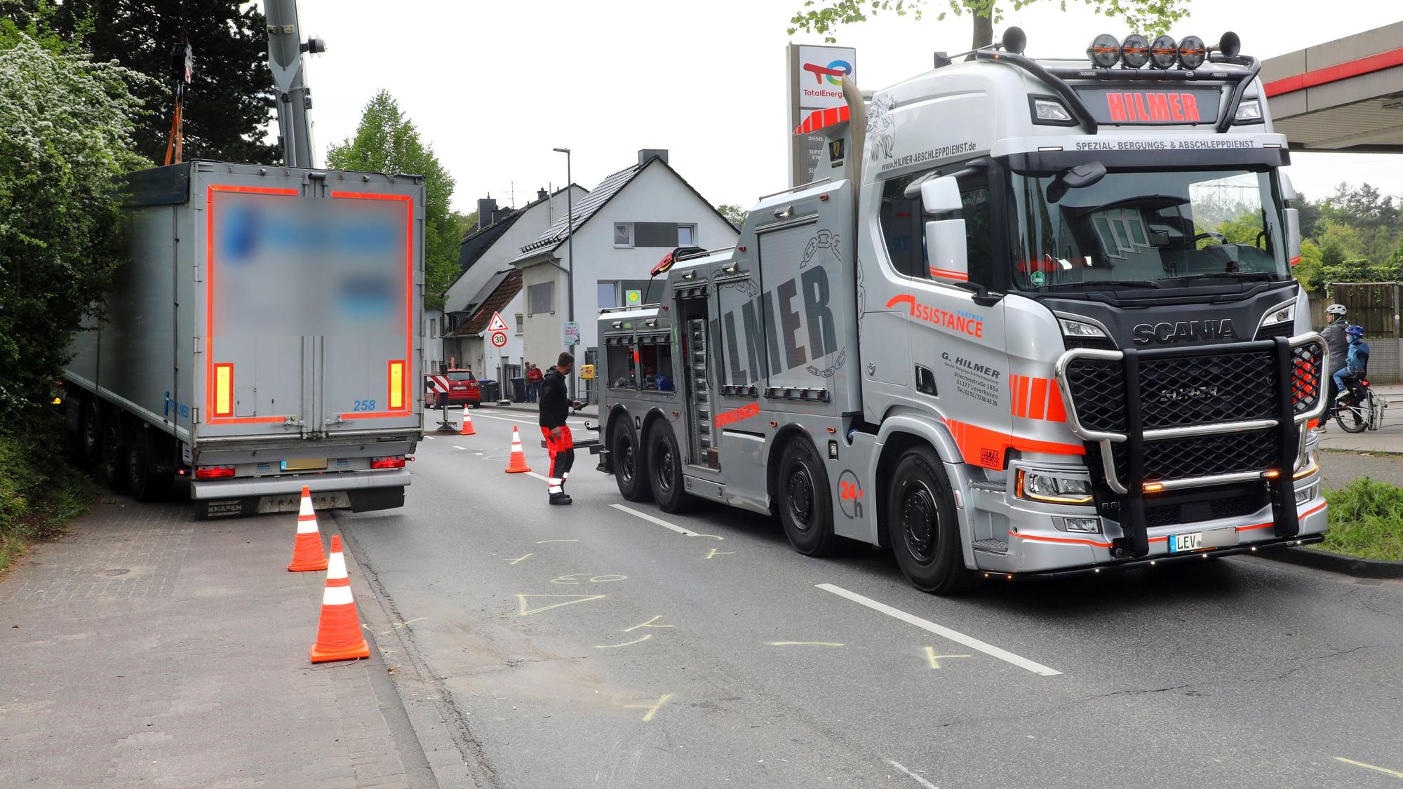 Ein Abschleppfahrzeug steht neben einem verunfallten Lkw auf der Bensberger Straße in Bergisch Gladbach-Heidkamp.