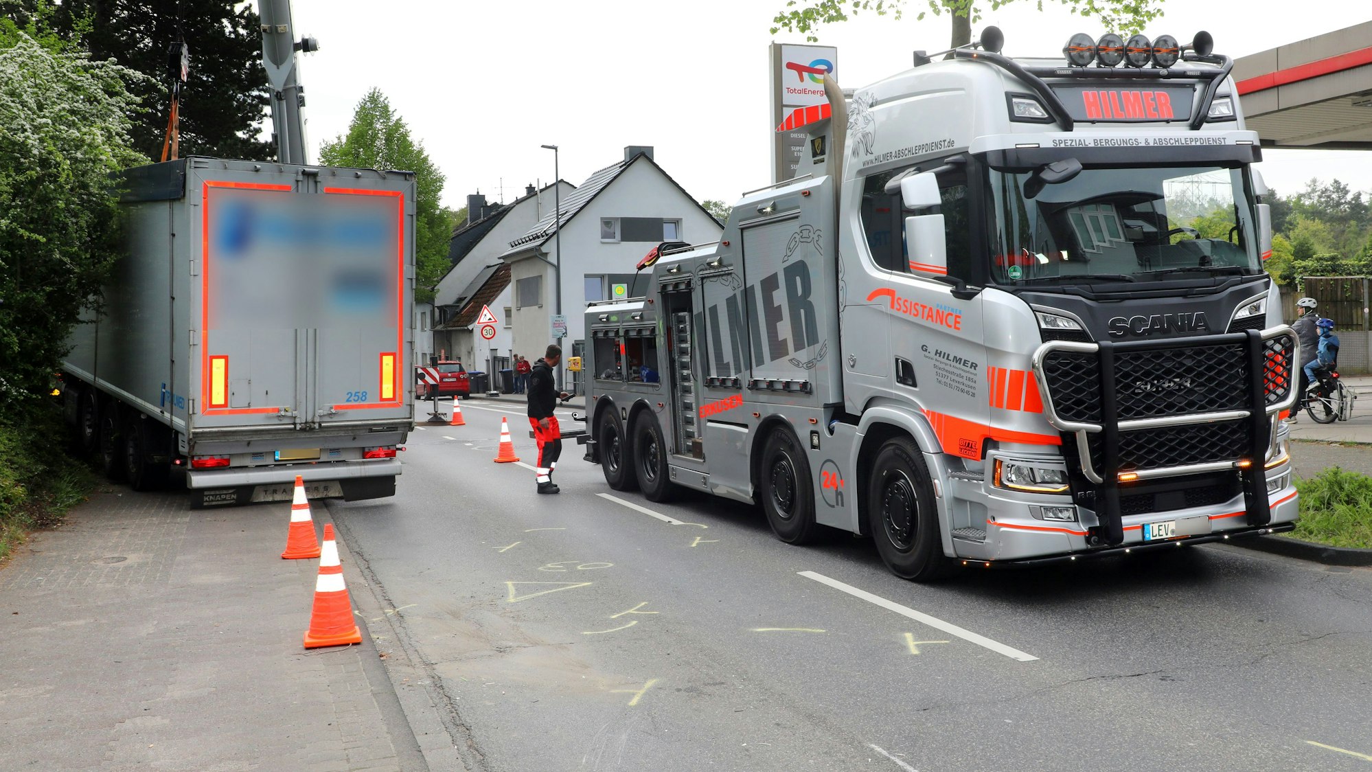 Ein Abschleppfahrzeug steht neben einem verunfallten Lkw auf der Bensberger Straße in Bergisch Gladbach-Heidkamp.