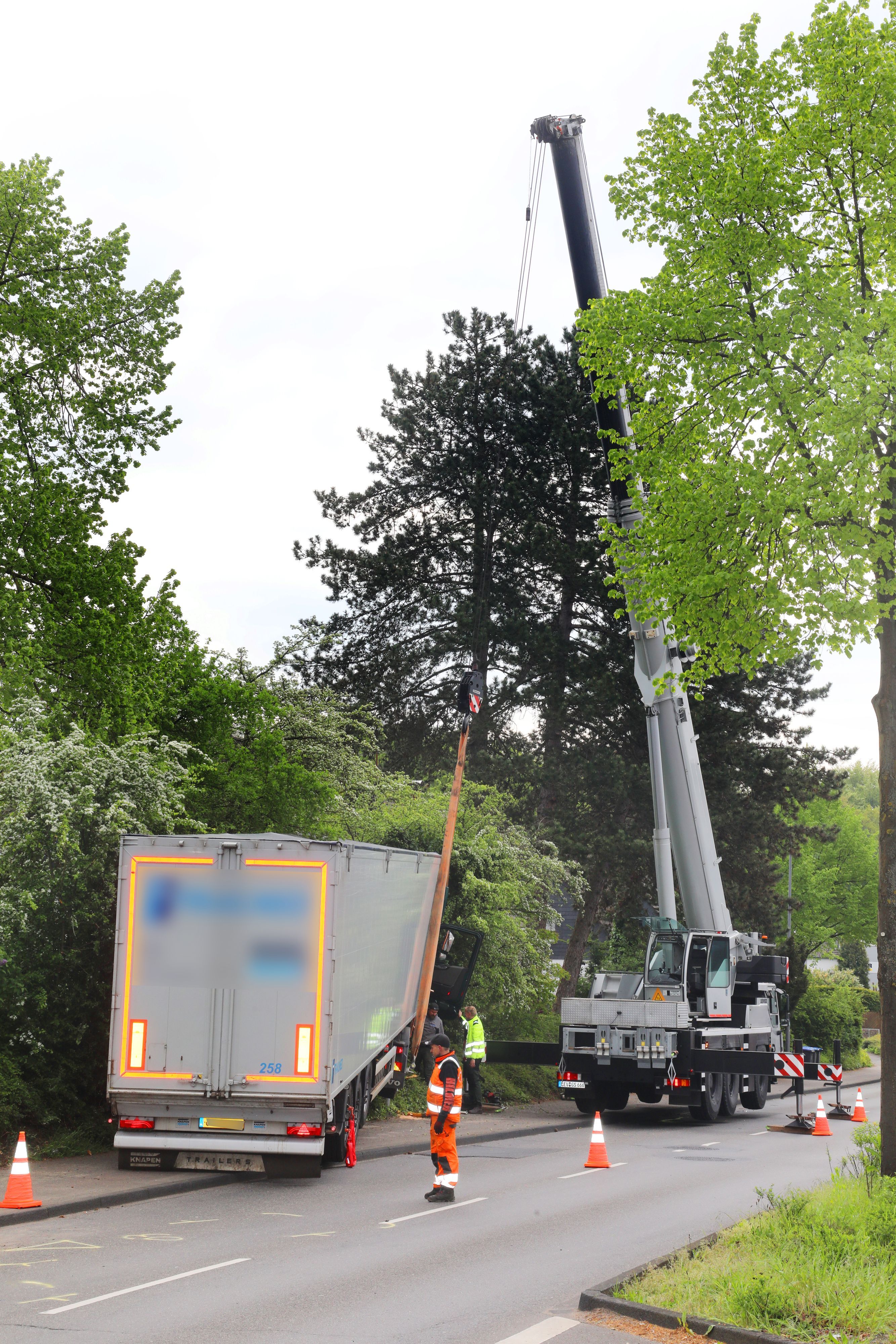 Ein Autokran hat einen Sattelzug am Haken.