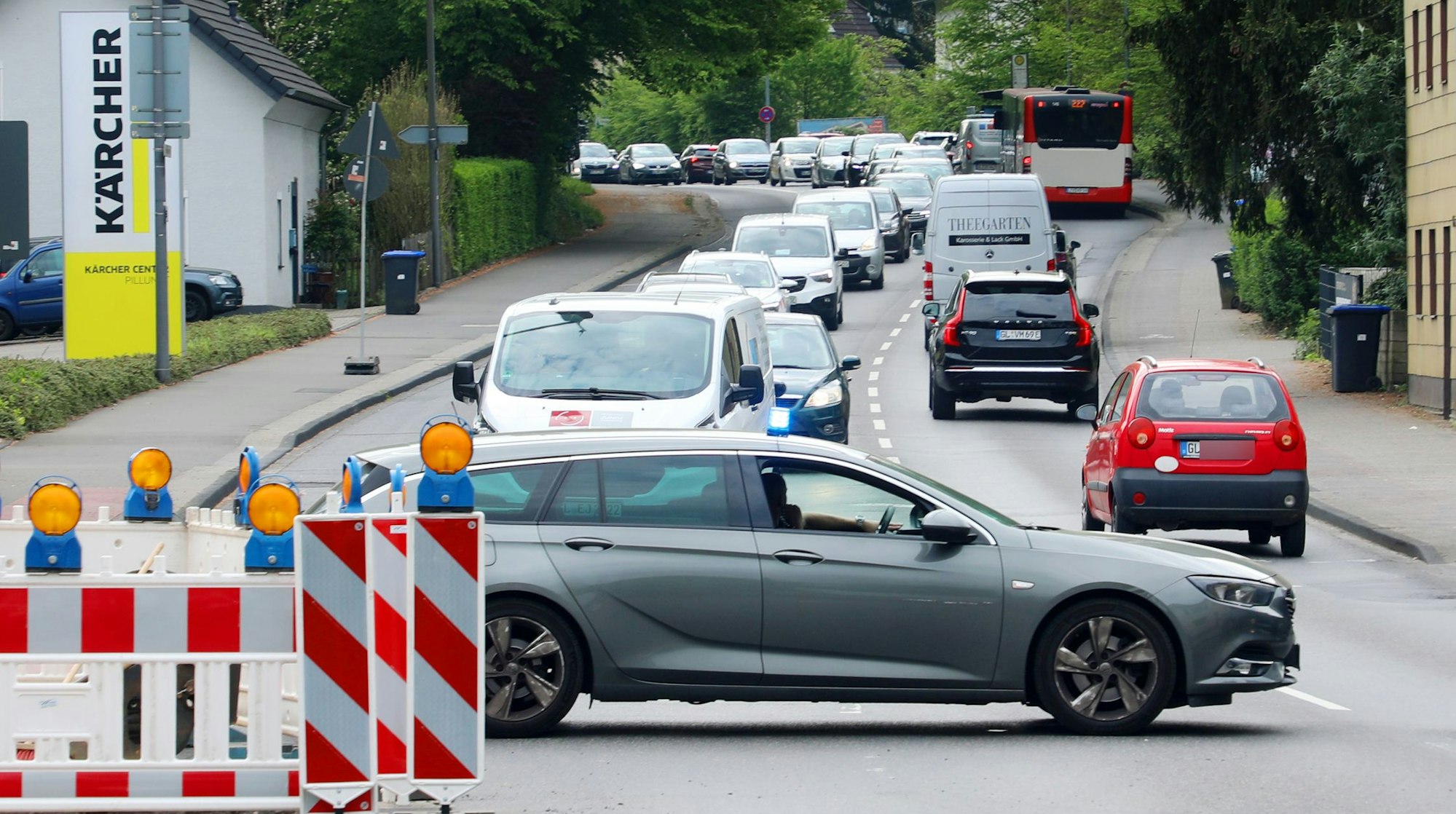 Ein Polizeiauto steht quer auf der Bensberger Straße in Bergisch Gladbach und sperrt diese wegen eines Unfalls ab.