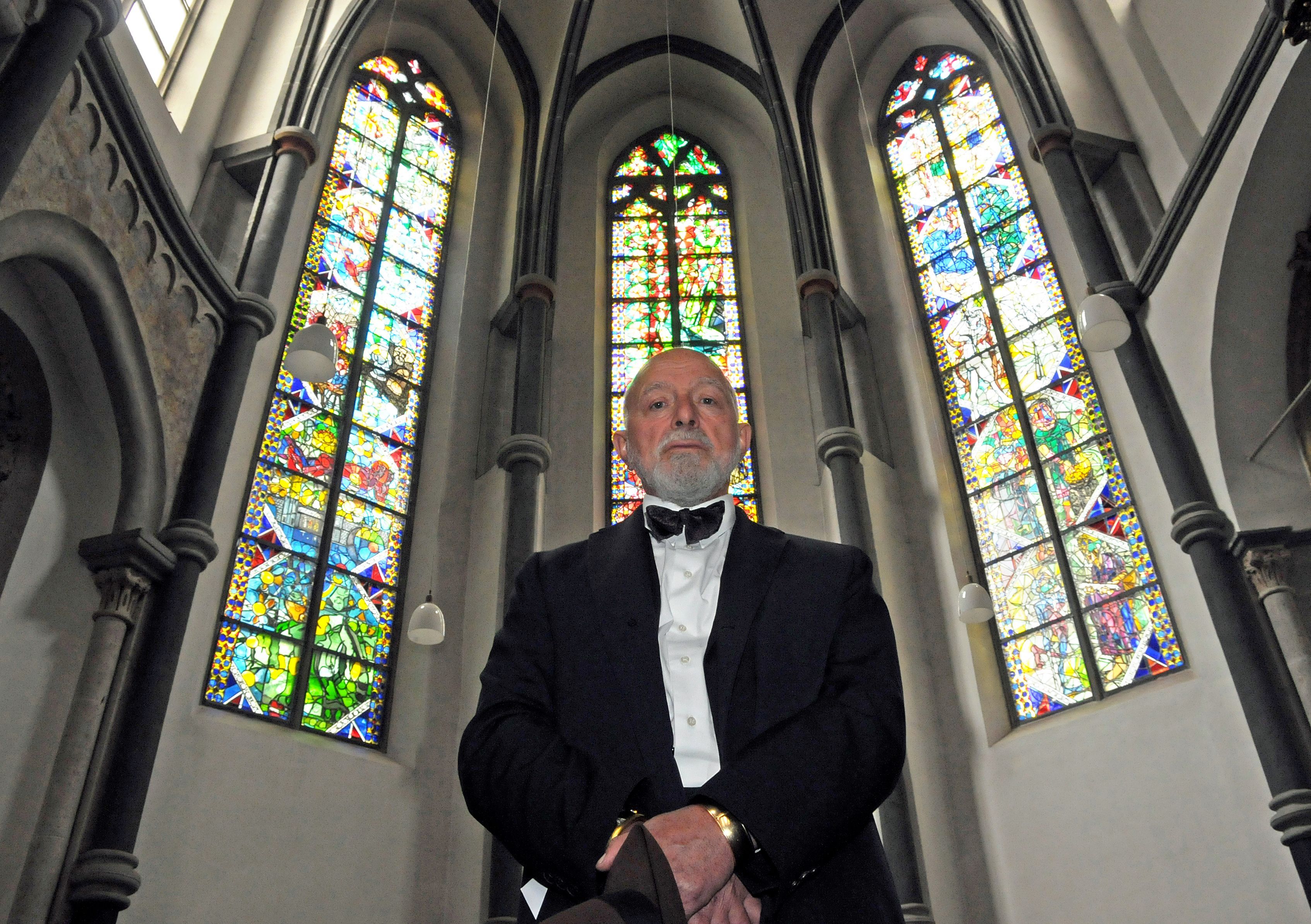 Der Künstler Markus Lüpertz posiert in Köln in der Kirche St. Andreas vor nach seinen Entwürfen gestalteten Fenstern.