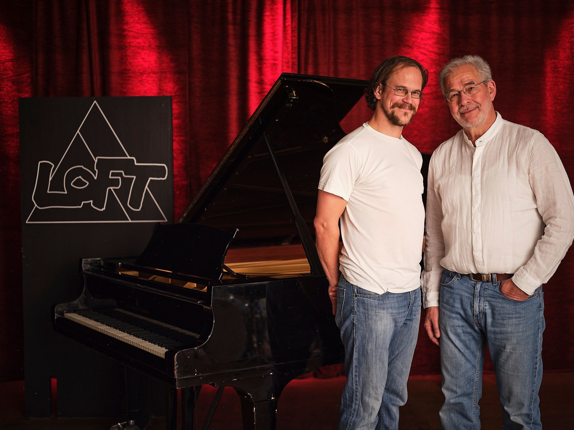 Hans Martin Schmid und Urs Benedikt vor schwarzem Flügel im Loft