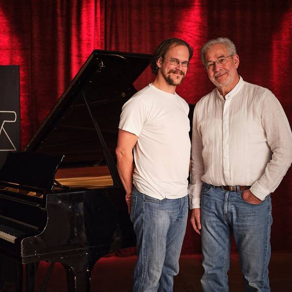 Hans Martin Schmid und Urs Benedikt vor schwarzem Flügel im Loft
