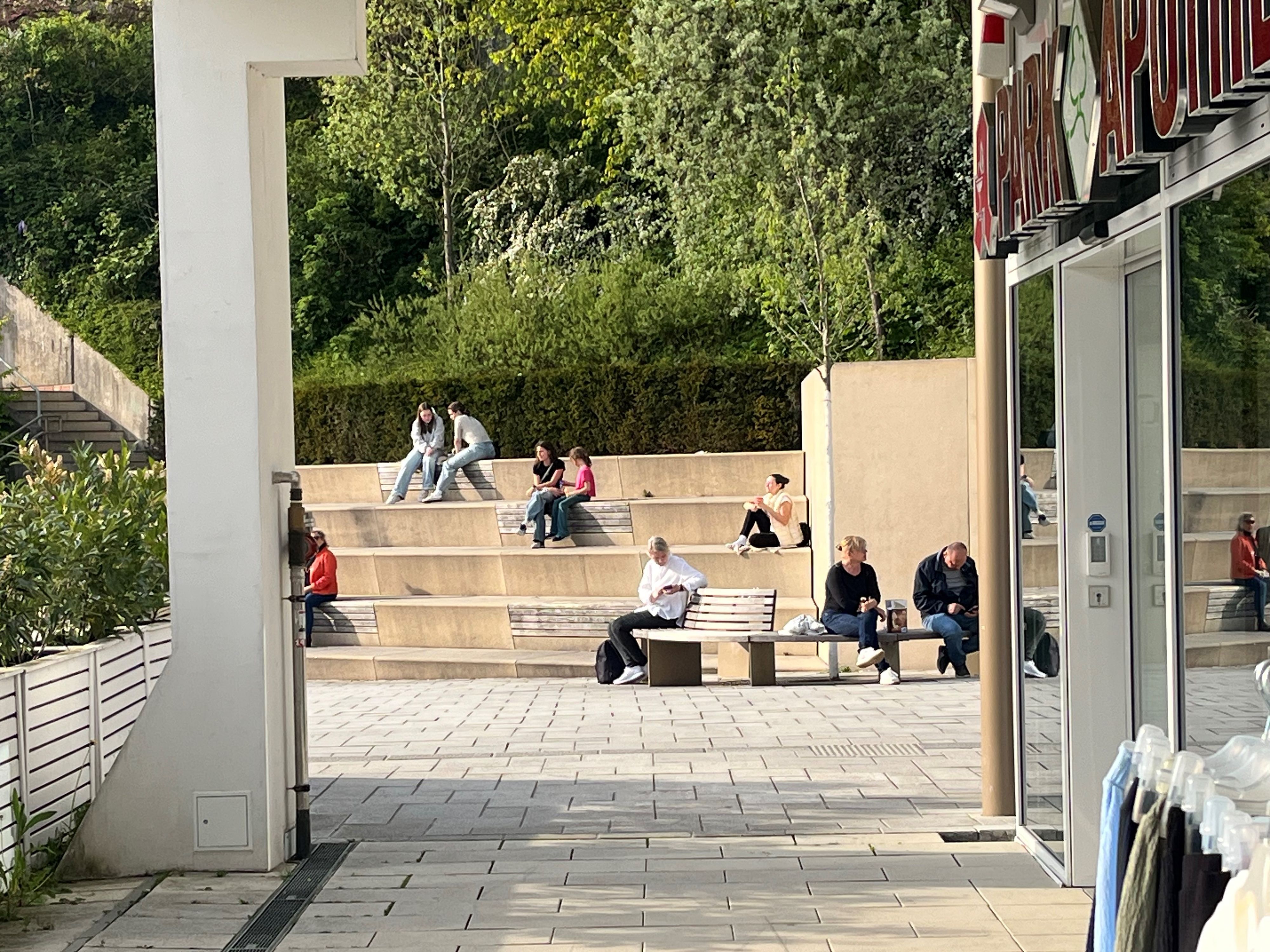 Menschen sitzen zu zweit oder zu dritt auf den Stufen.