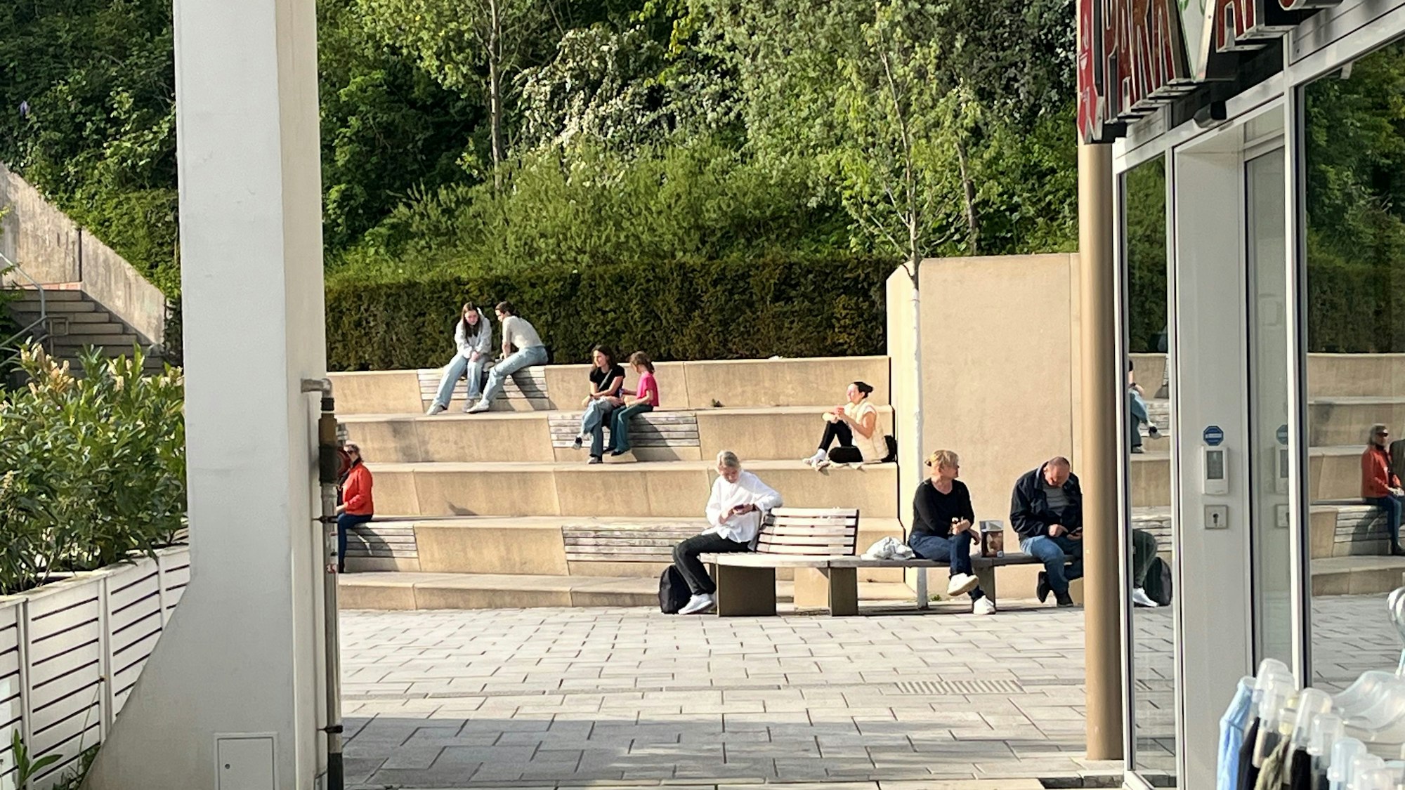 Menschen sitzen zu zweit oder zu dritt auf den Stufen.