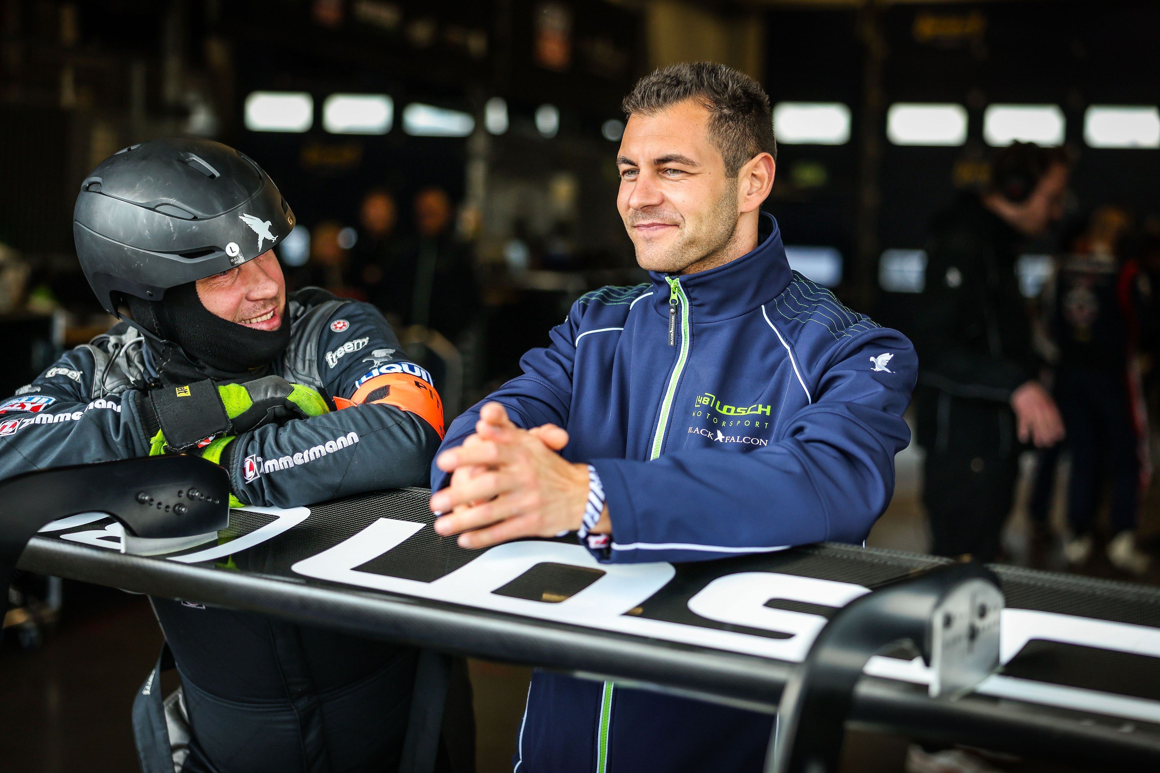 Tobias Müller lehnt sich auf einen Spoiler und unterhält sich mit einem Mechaniker.