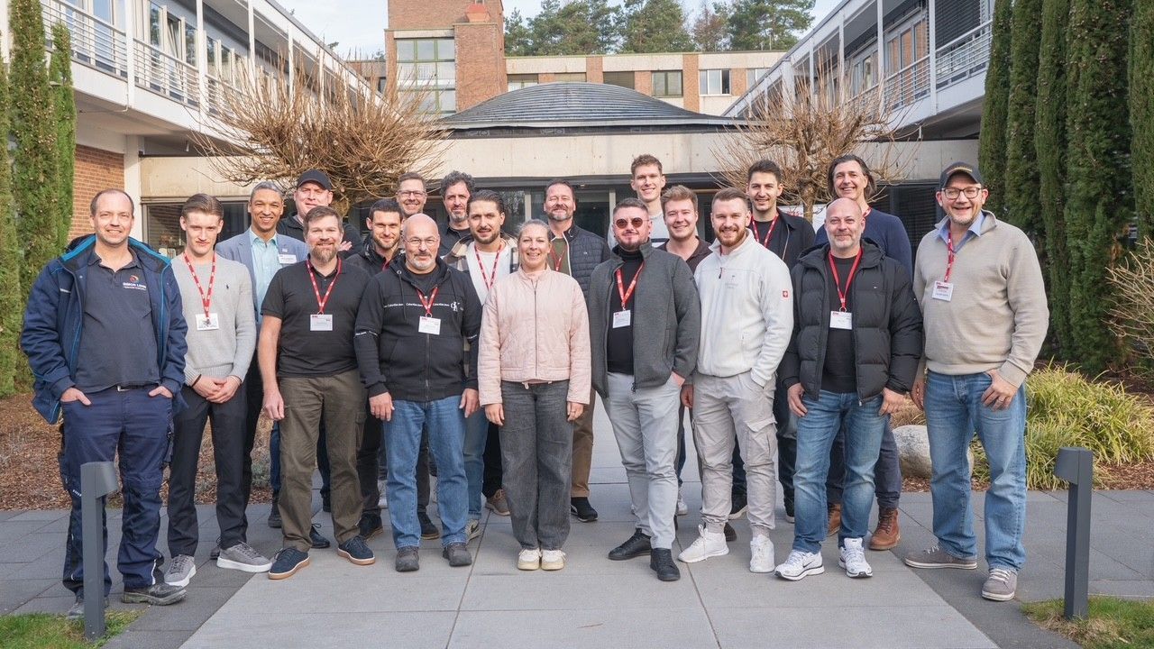 Eine Gruppe steht beieinander und alle lächeln in die Kamera.