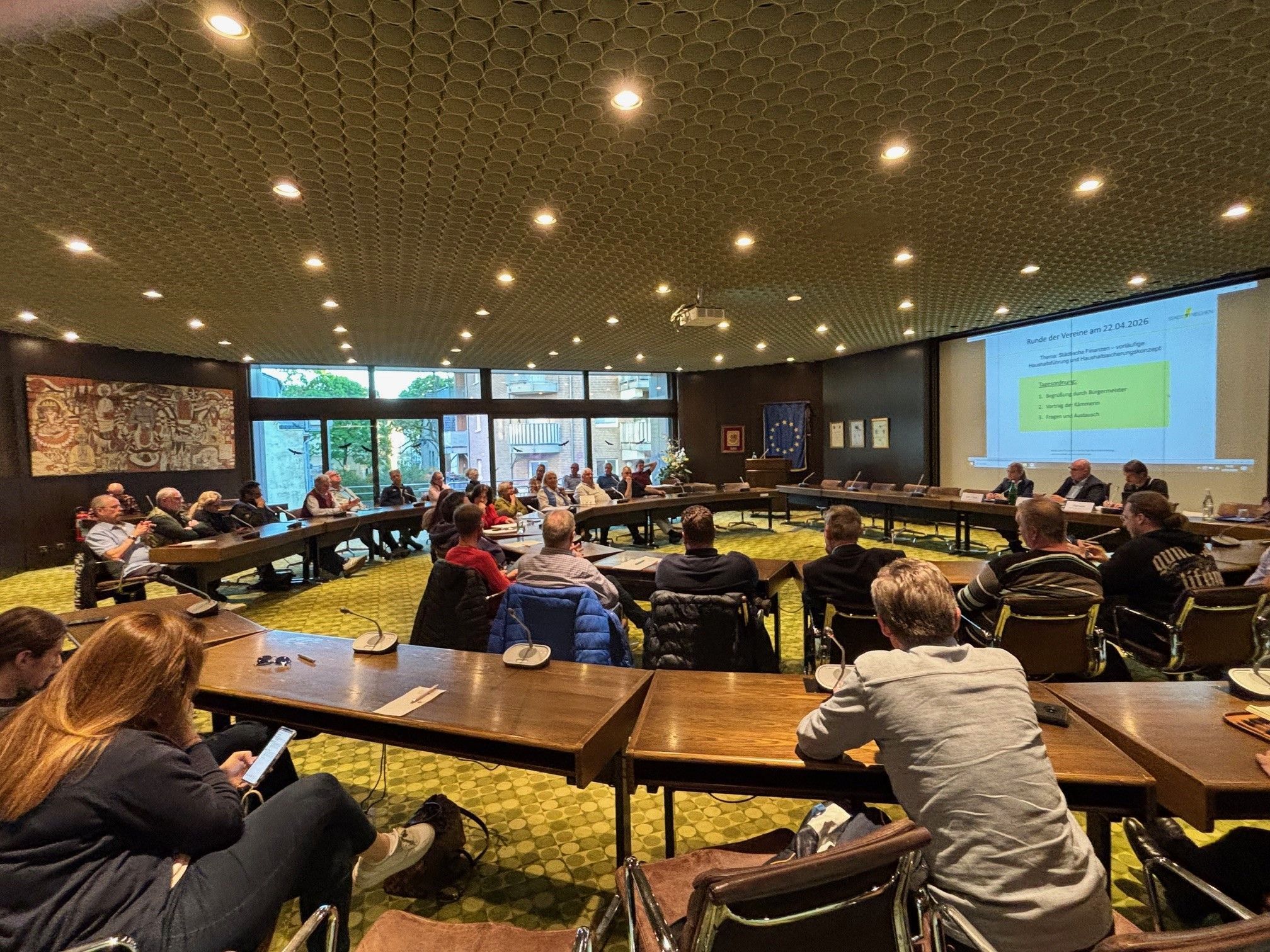 Auf dem Bild ist eine Versammlung im Ratssaal Frechen zu sehen.