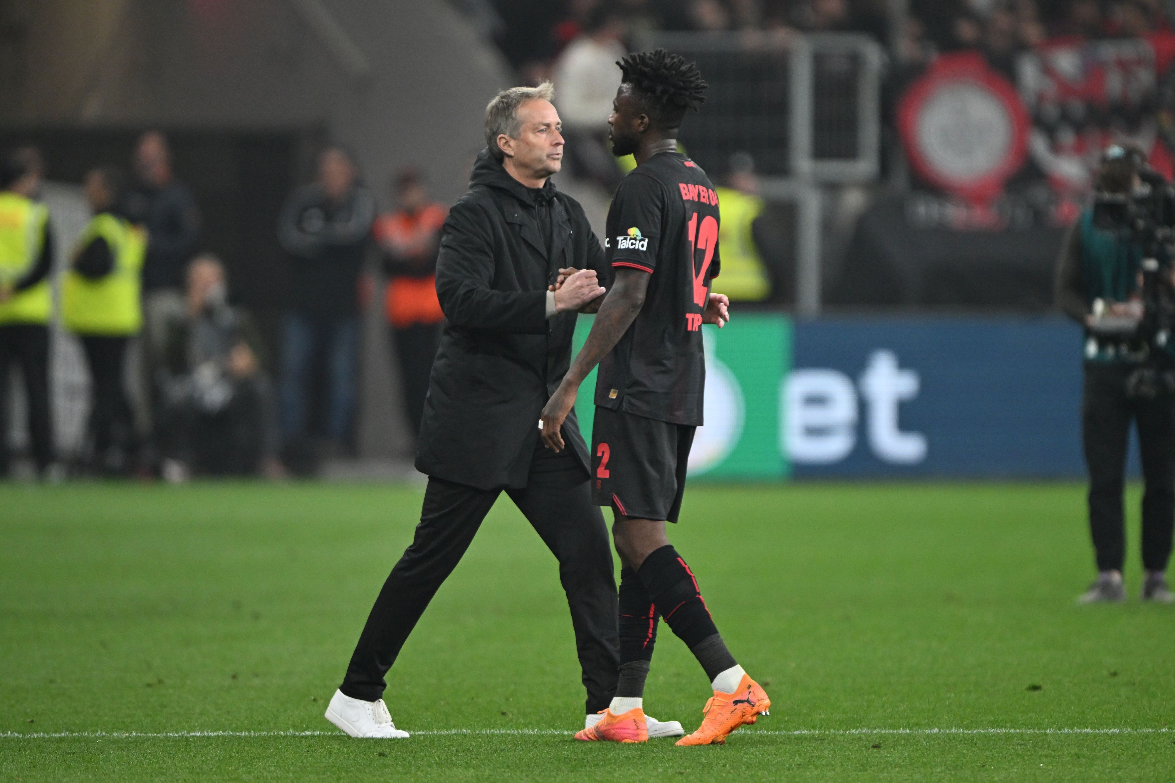 22.04.2026, Nordrhein-Westfalen, Leverkusen: Fußball, Männer: DFB-Pokal, Bayer Leverkusen - Bayern München, Halbfinale, BayArena, Trainer Kasper Hjulmand (Bayer Leverkusen) und Edmond Tapsoba (Bayer Leverkusen) schütteln sich nach der Partie die Hand. WICHTIGER HINWEIS: Gemäß den Vorgaben der DFL Deutsche Fußball Liga bzw. des DFB Deutscher Fußball-Bund ist es untersagt, in dem Stadion und/oder vom Spiel angefertigte Fotoaufnahmen in Form von Sequenzbildern und/oder videoähnlichen Fotostrecken zu verwerten bzw. verwerten zu lassen. Foto: Federico Gambarini/dpa +++ dpa-Bildfunk +++