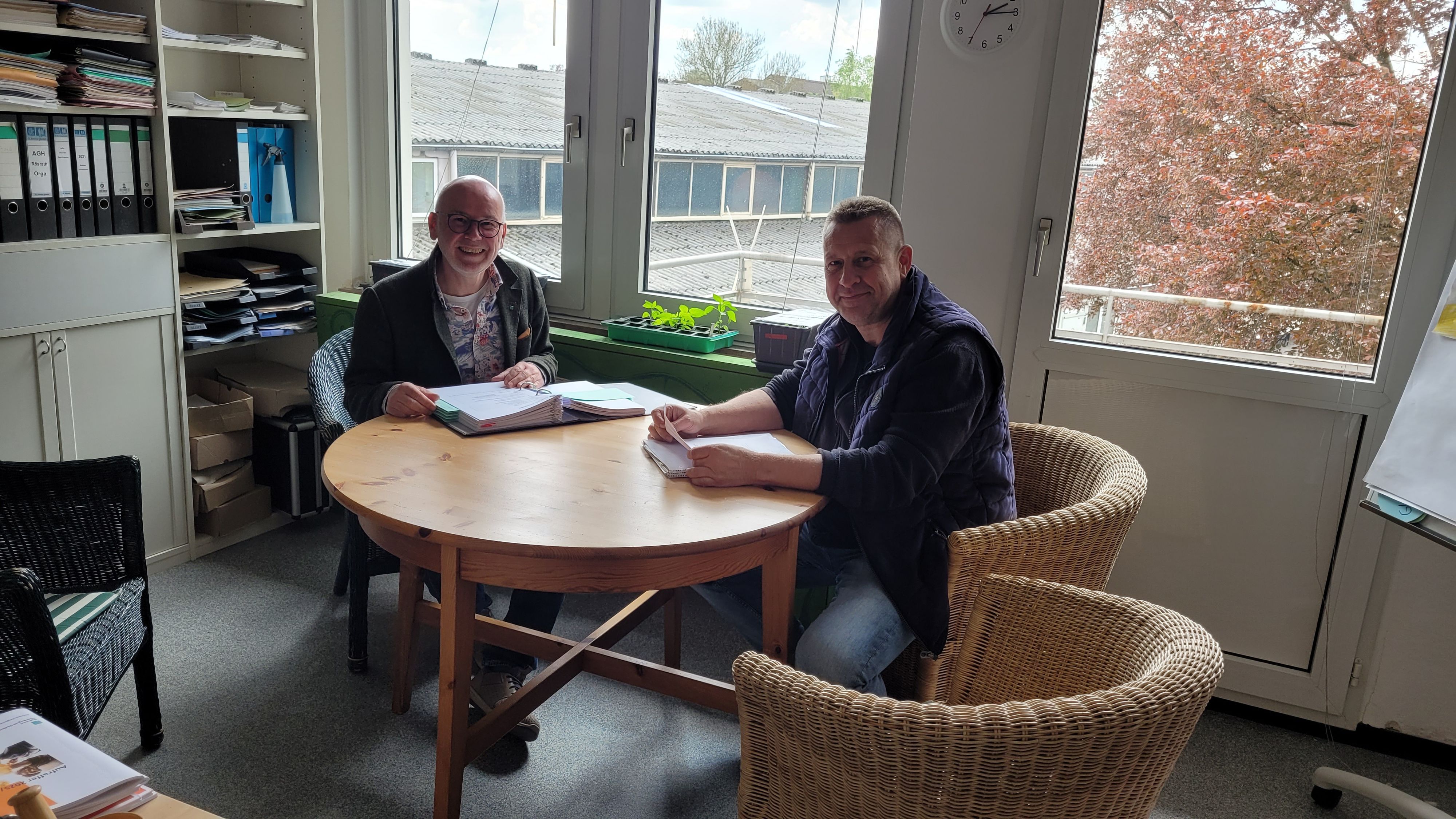 Zwei Männer sitzen an einem Tisch.