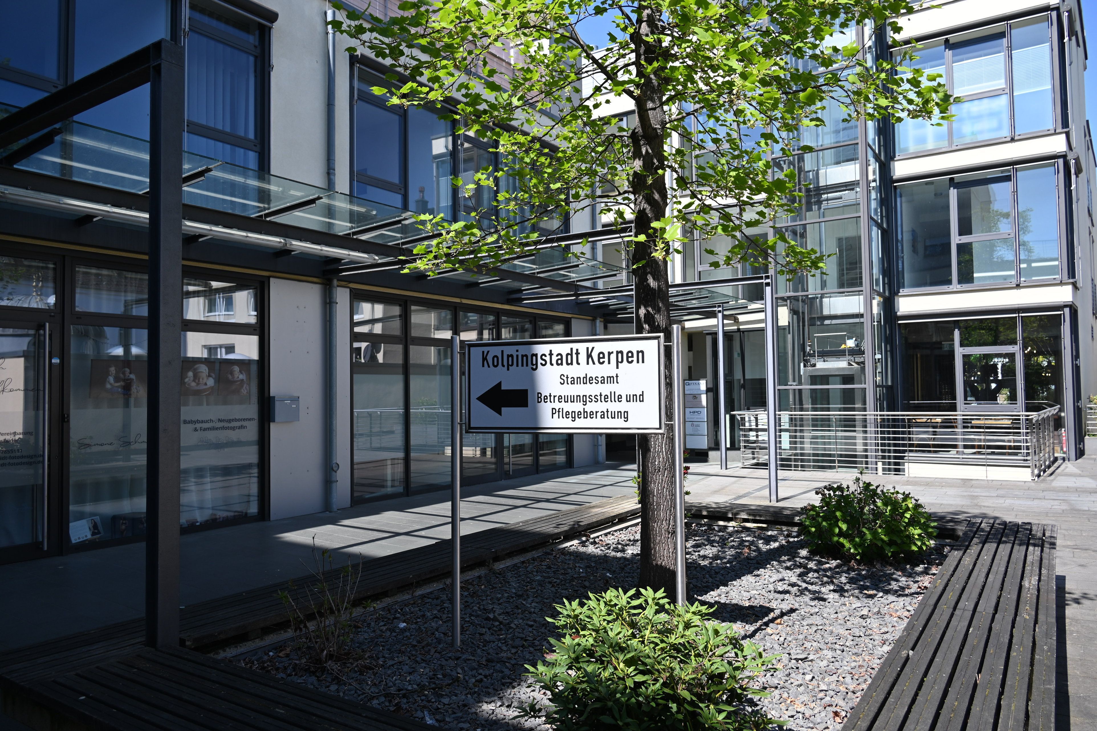 Das Foto zeigt ein Gebäude mit Glasfronten, davor steht ein Schild mit der Aufschrift „Kolpingstadt Kerpen“.