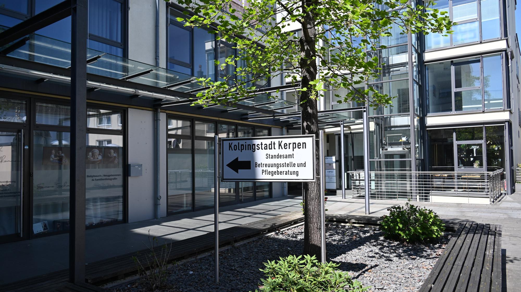 Das Foto zeigt ein Gebäude mit Glasfronten, davor steht ein Schild mit der Aufschrift „Kolpingstadt Kerpen“.