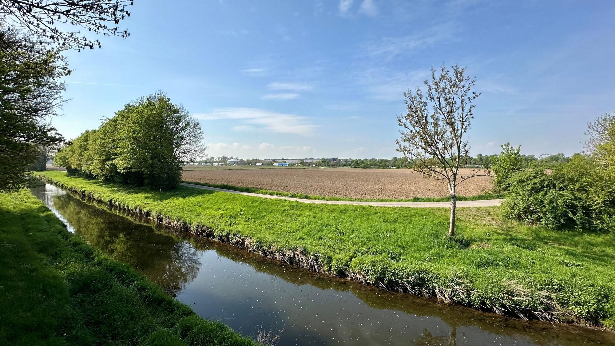 Das Bild zeigt die Erft bei Liblar und Bliesheim, im Hintergrund ist die Autobahn zu sehen.