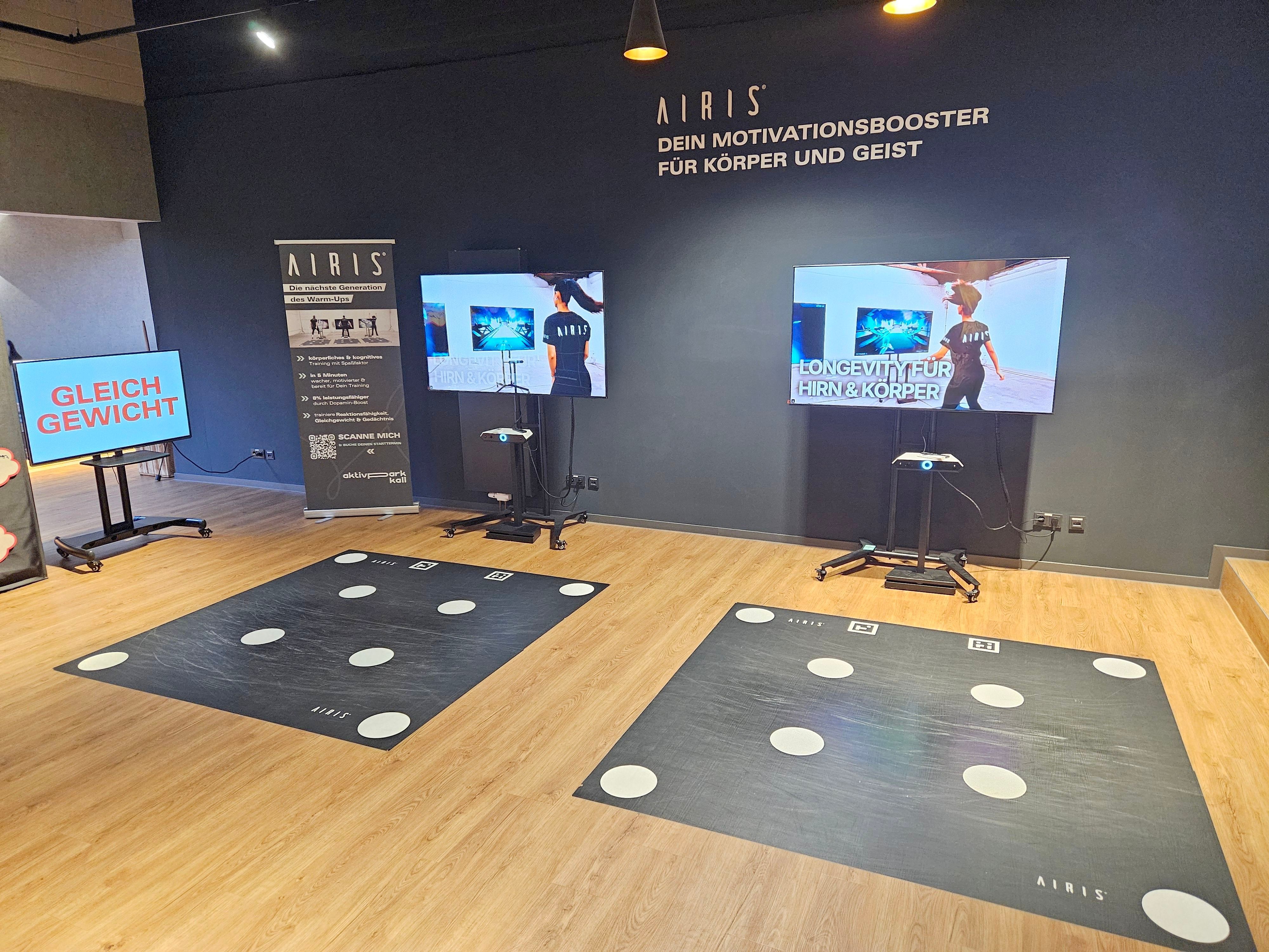 Blick auf zwei große Bildschirme mit Koordinationsmatten davor.