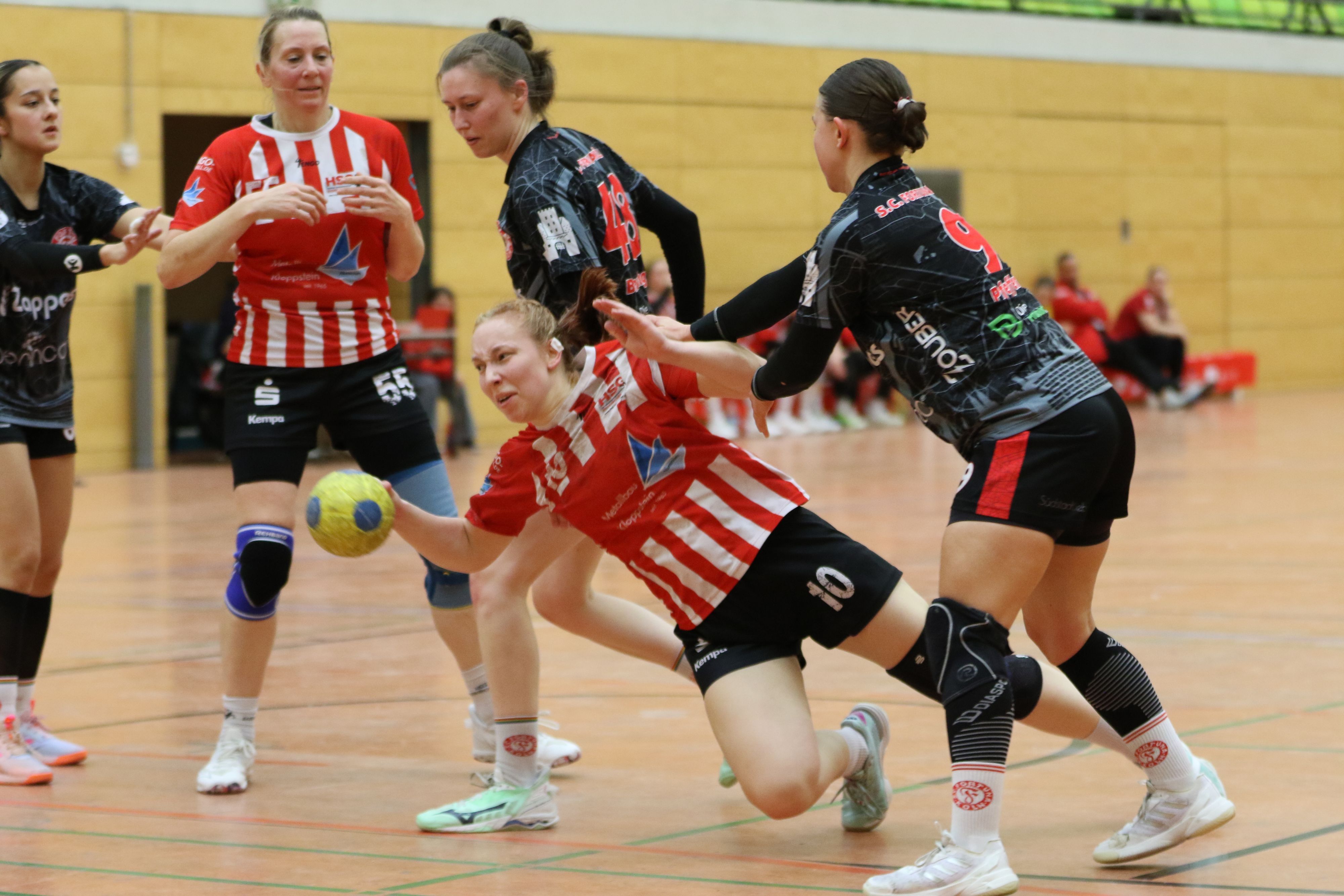 Das Foto zeigt ein Szene aus einem Handballspiel. Kein Durchkommen für Lea Schmitz, die hier unsanft Kontakt zum Boden findet.
