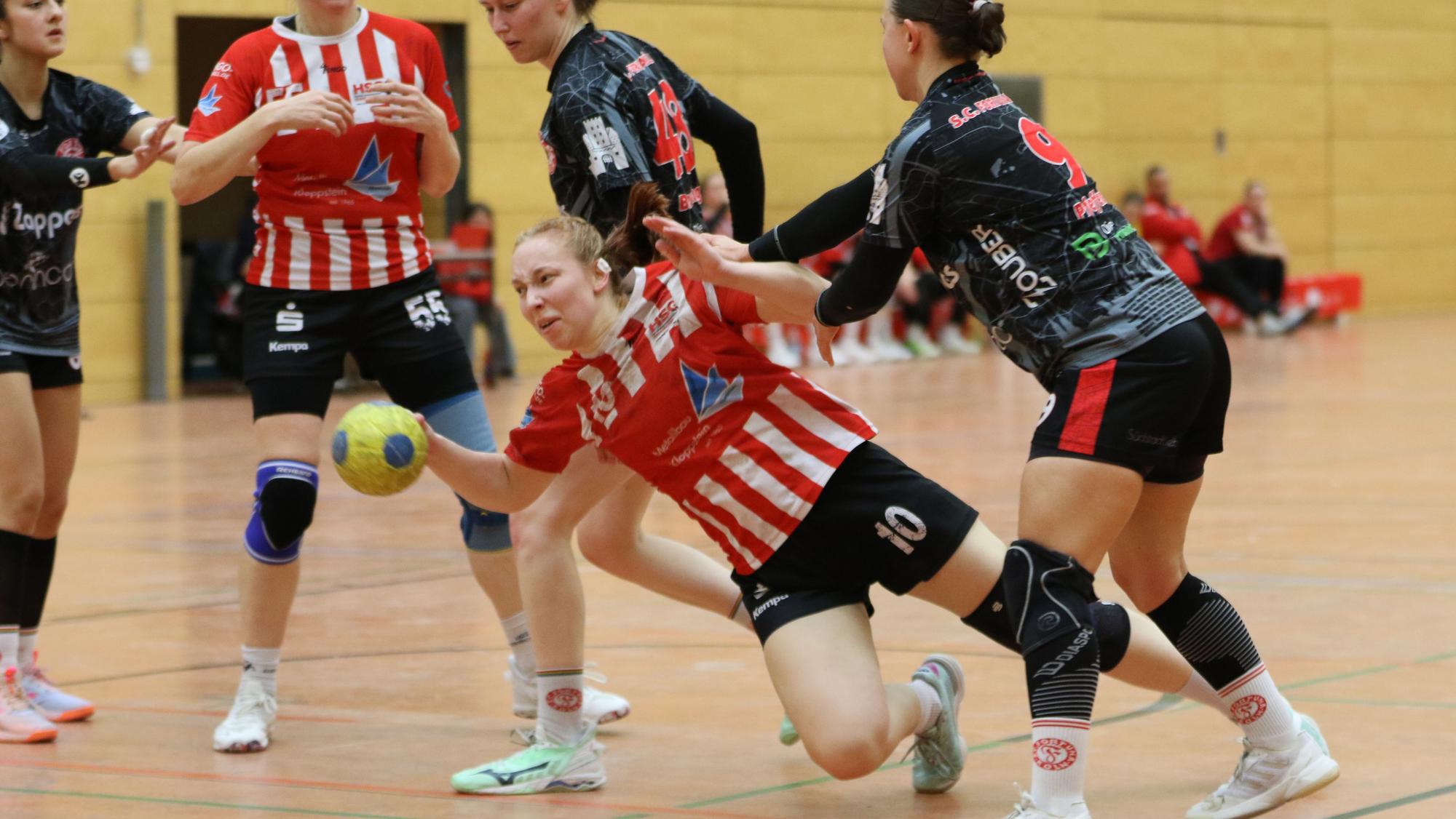 Das Foto zeigt ein Szene aus einem Handballspiel. Kein Durchkommen für Lea Schmitz, die hier unsanft Kontakt zum Boden findet.