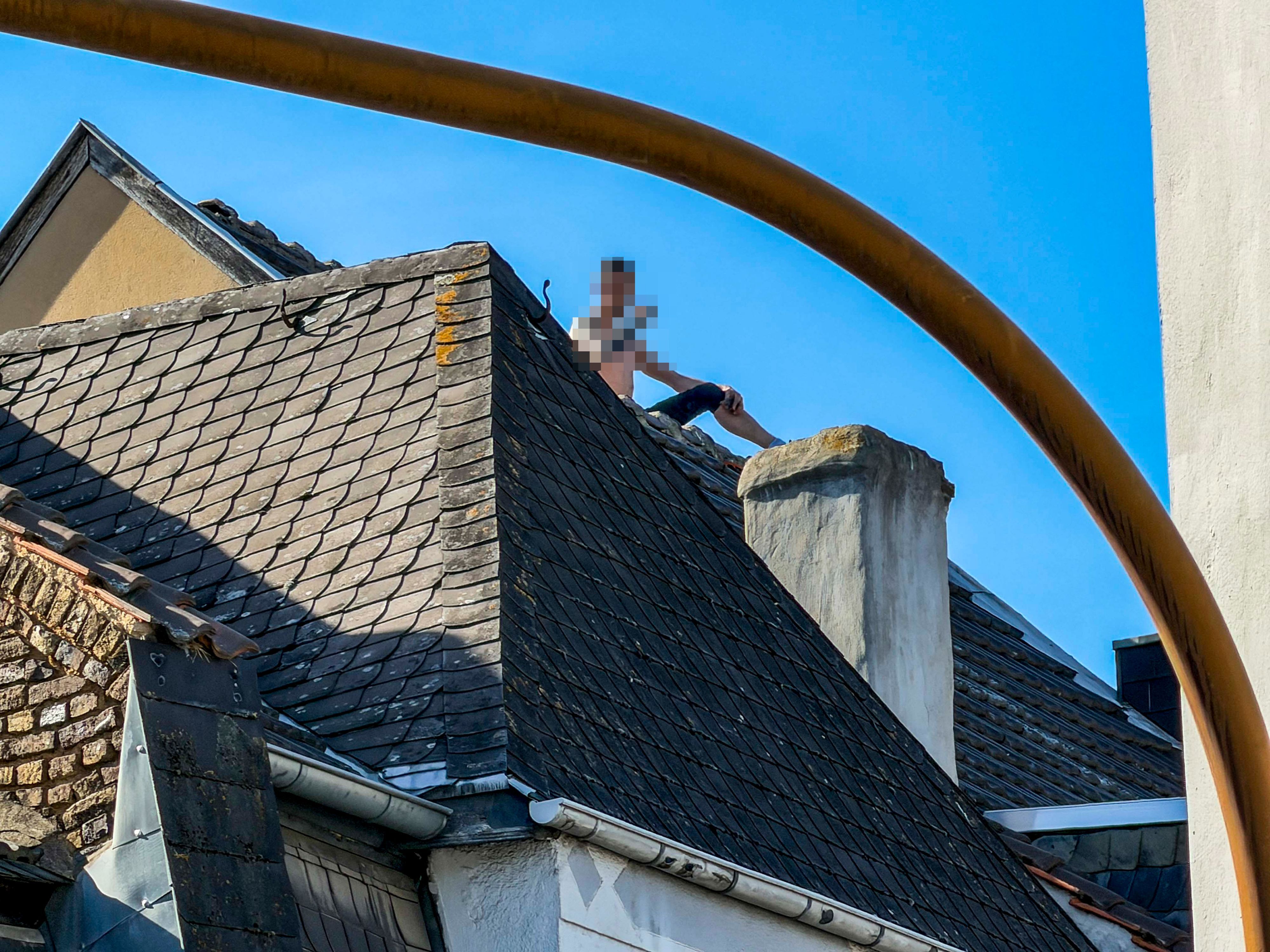 Das Bild zeigt den Mann, wie er auf dem Dach eines Hauses in Euskirchen sitzt.