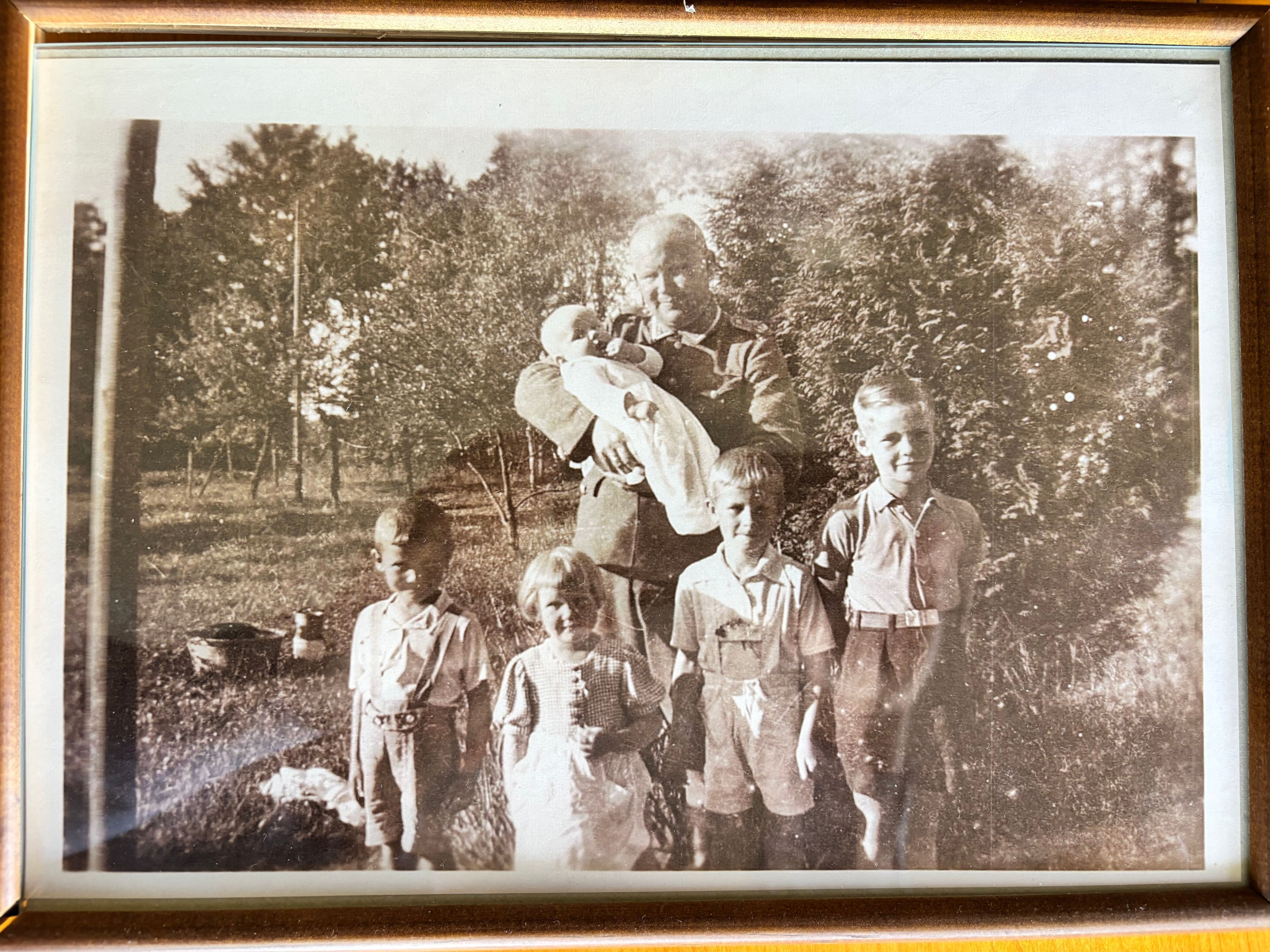 Das Schwarz-Weiß-Foto zeigt einen Mann mit fünf Kindern. Das Baby hält er auf dem Arm, die vier Kinder stehen vor ihm.