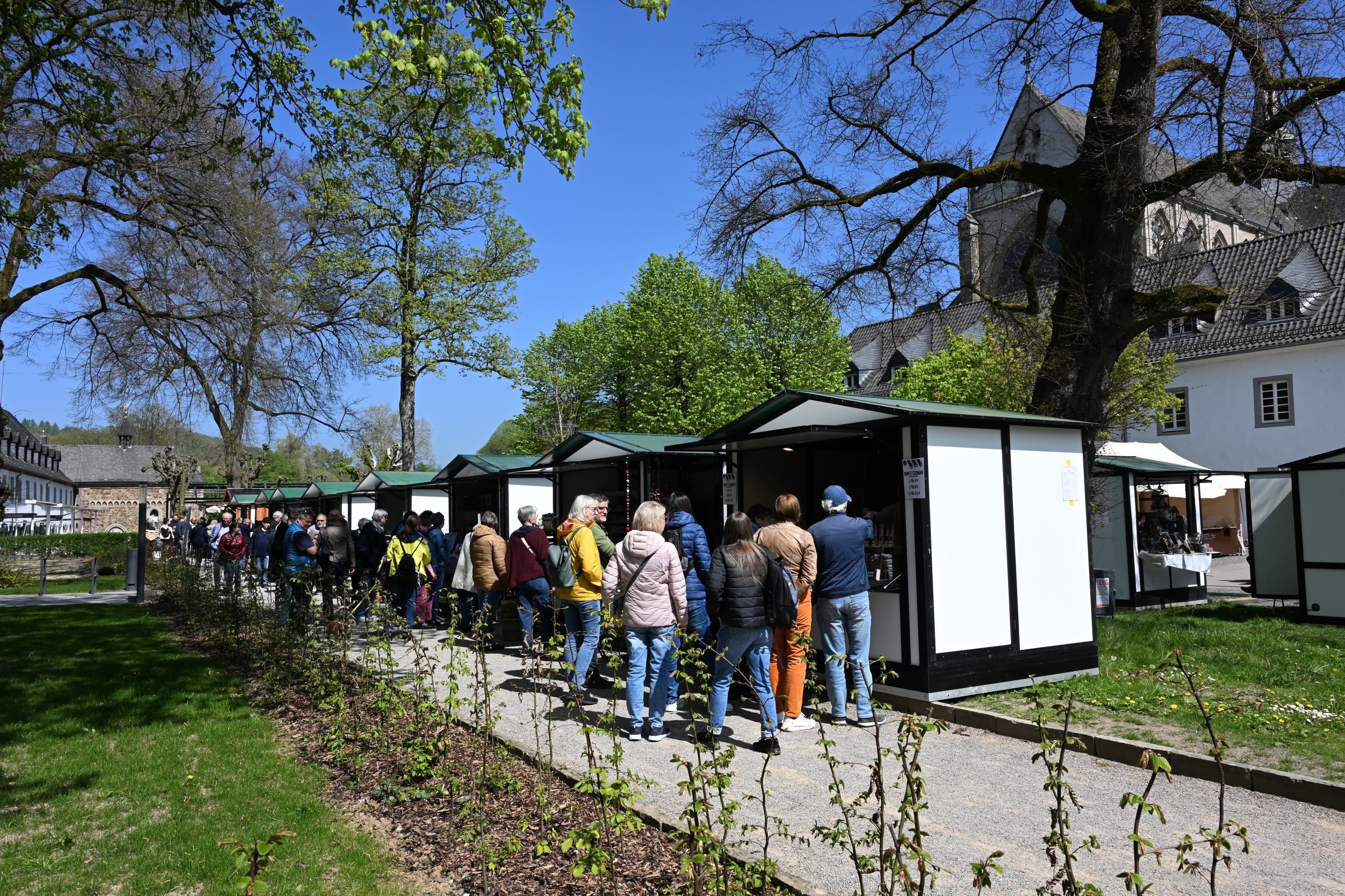 Besucher laufen an Marktständen vorbei.