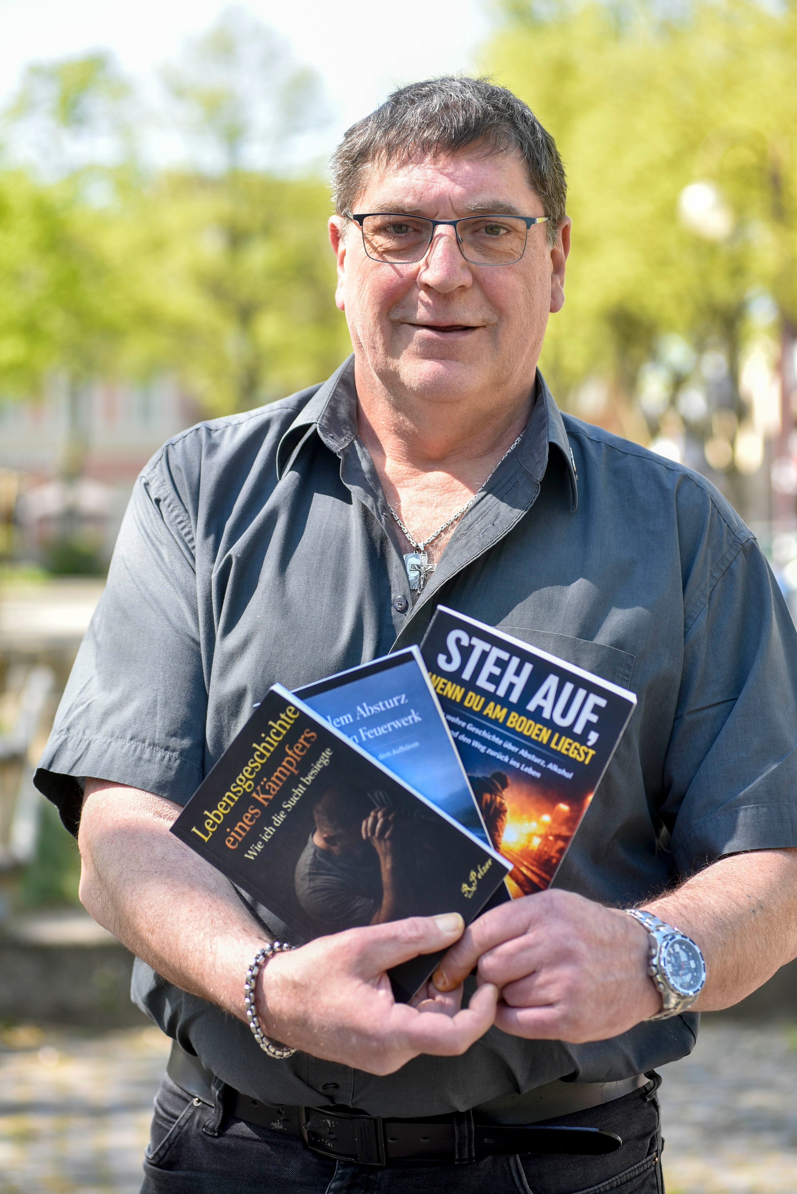 Das Foto zeigt das Portrait eines Mannes mit Brille und einem grauen Hemd.