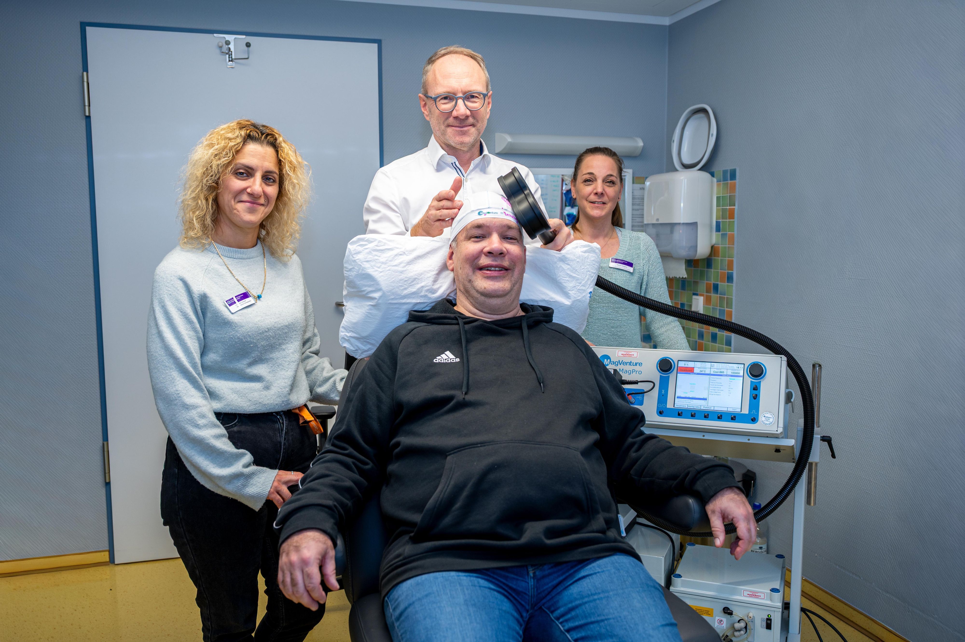 Ein Arzt legt einem Patienten eine Magnetspule auf den Kopf.