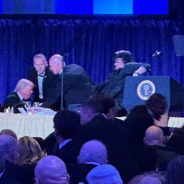 US-Präsident Donald Trump (l) sitzt auf der Bühne, während Agenten des US-Geheimdienstes ihn nach einem Vorfall außerhalb des Ballsaals während des White House Correspondents' Dinner aus dem Ballsaal bringen.