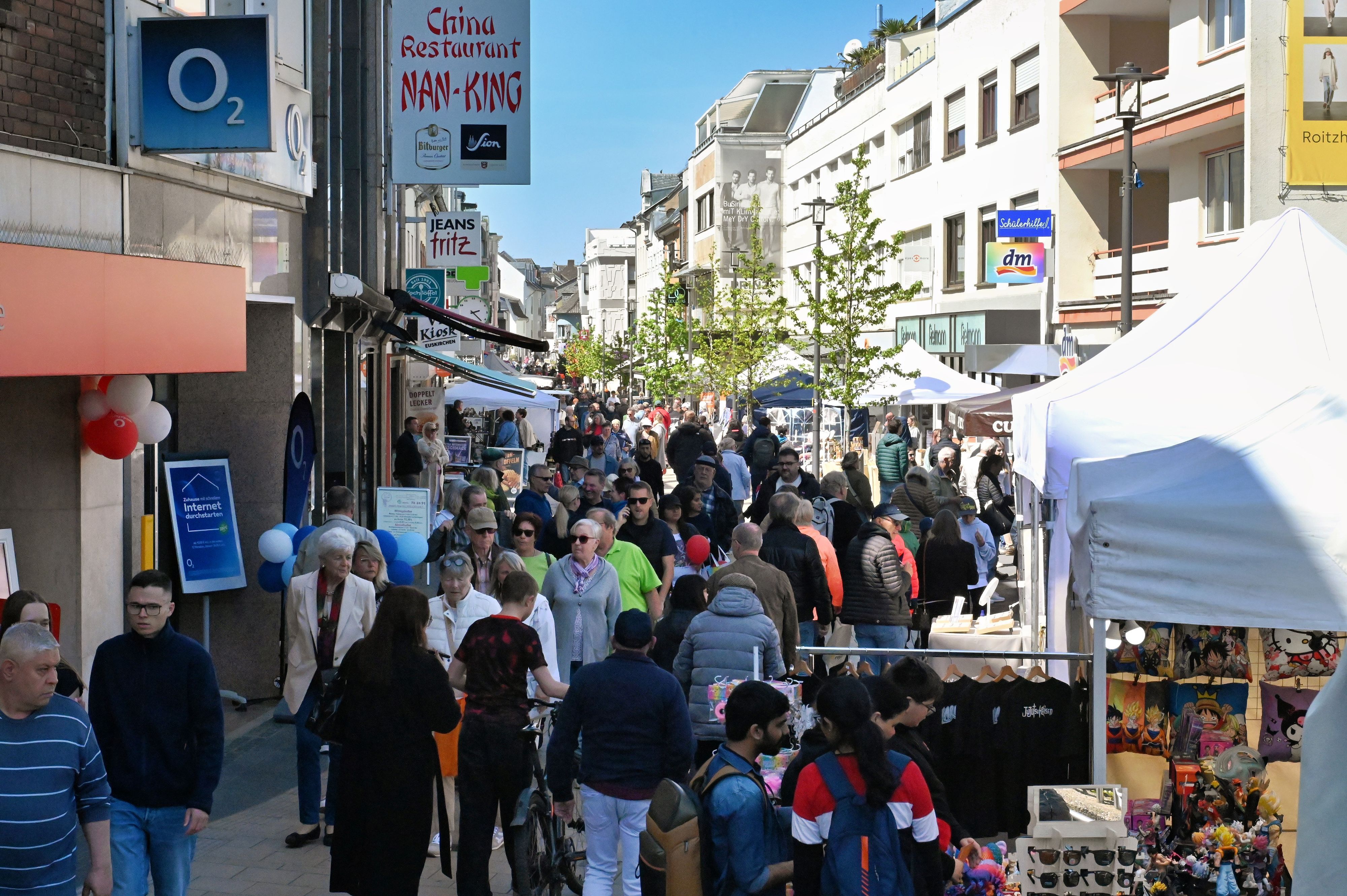In der Innenstadt schlendern viele Menschen an den Ständen vorbei.