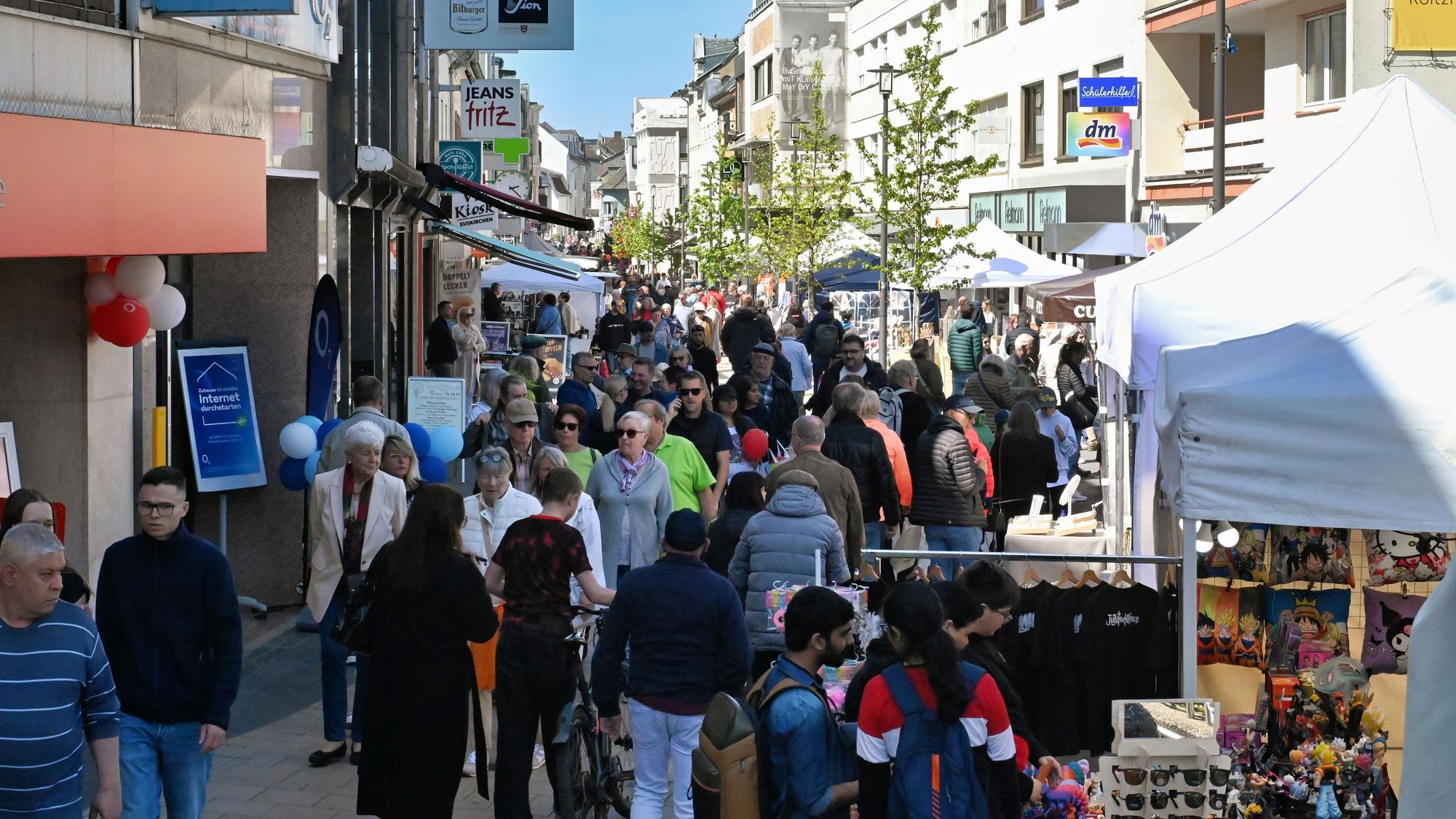 In der Innenstadt schlendern viele Menschen an den Ständen vorbei.
