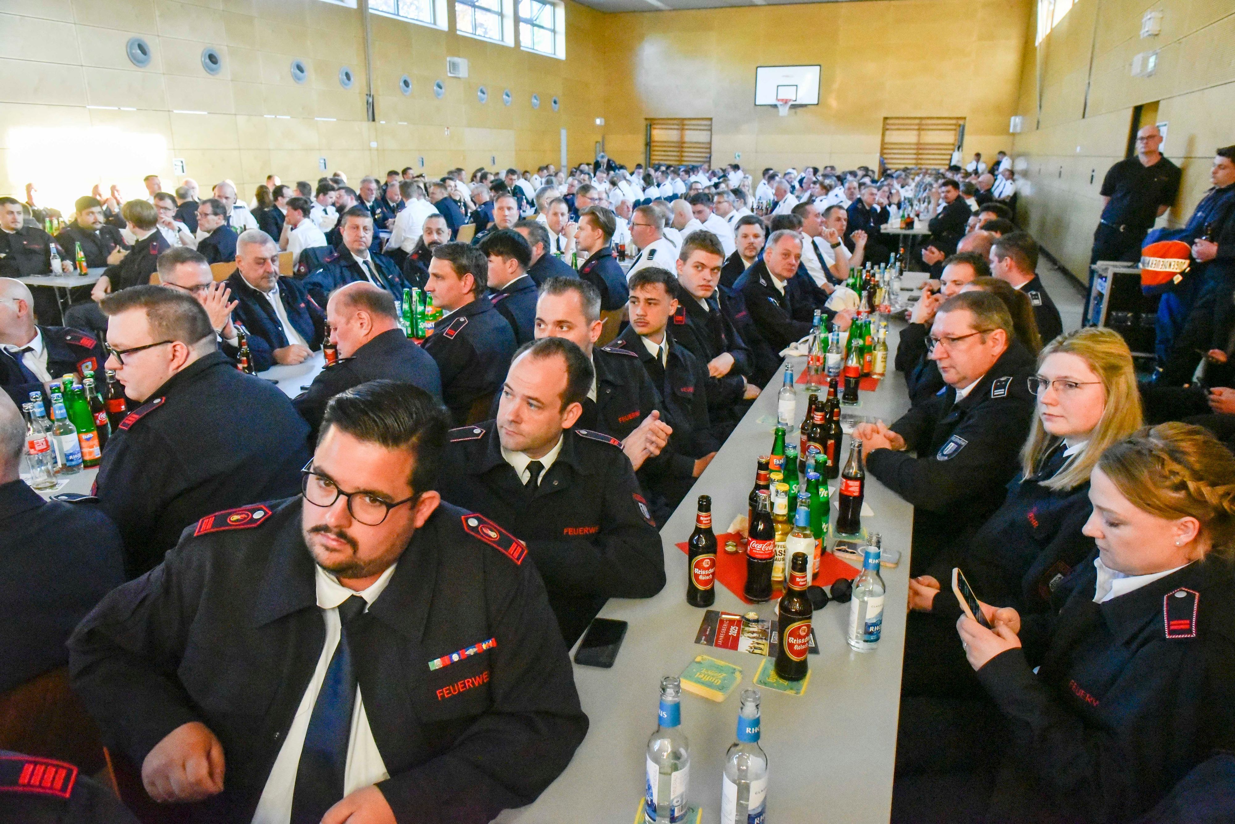 Auf dem Bild sind Teilnehmer der Delegiertenversammlung in Uniform an langen Tischen zu sehen.