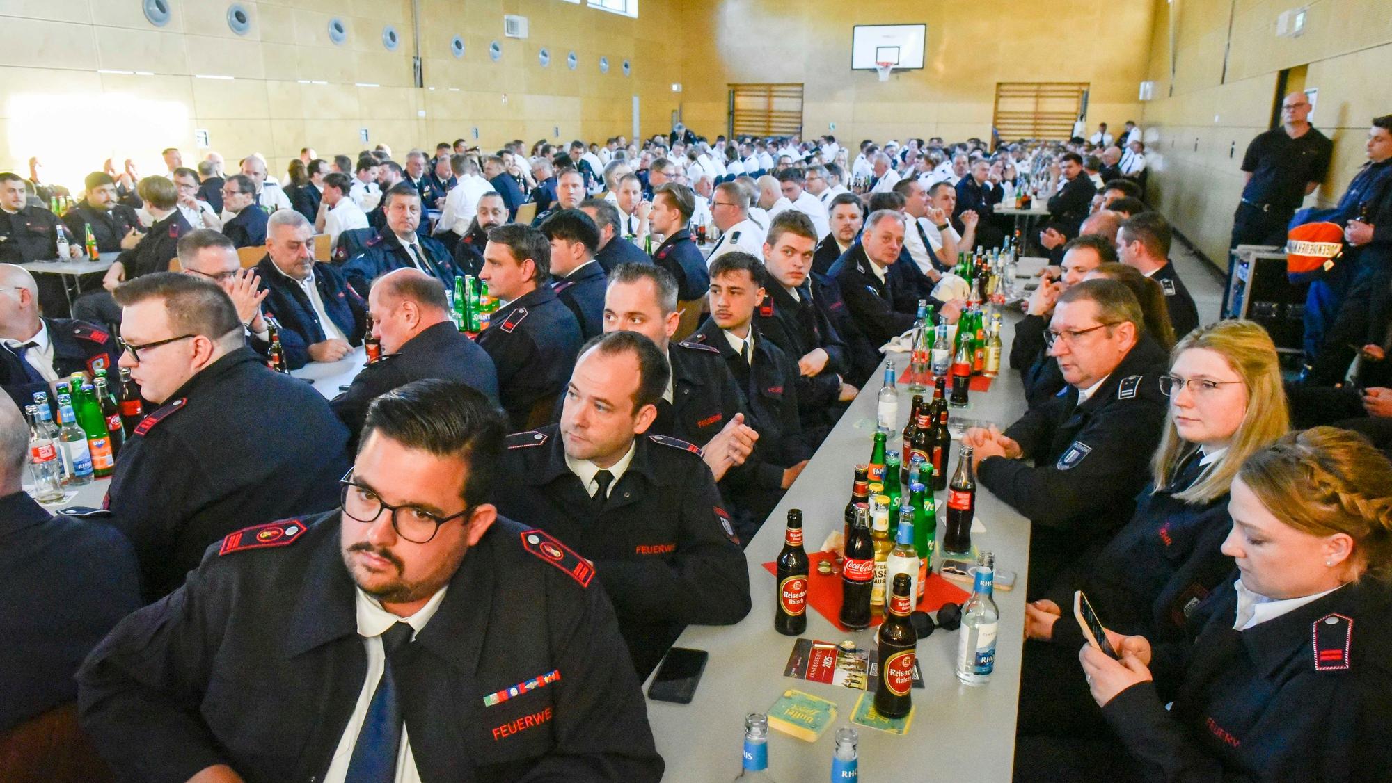 Auf dem Bild sind Teilnehmer der Delegiertenversammlung in Uniform an langen Tischen zu sehen.