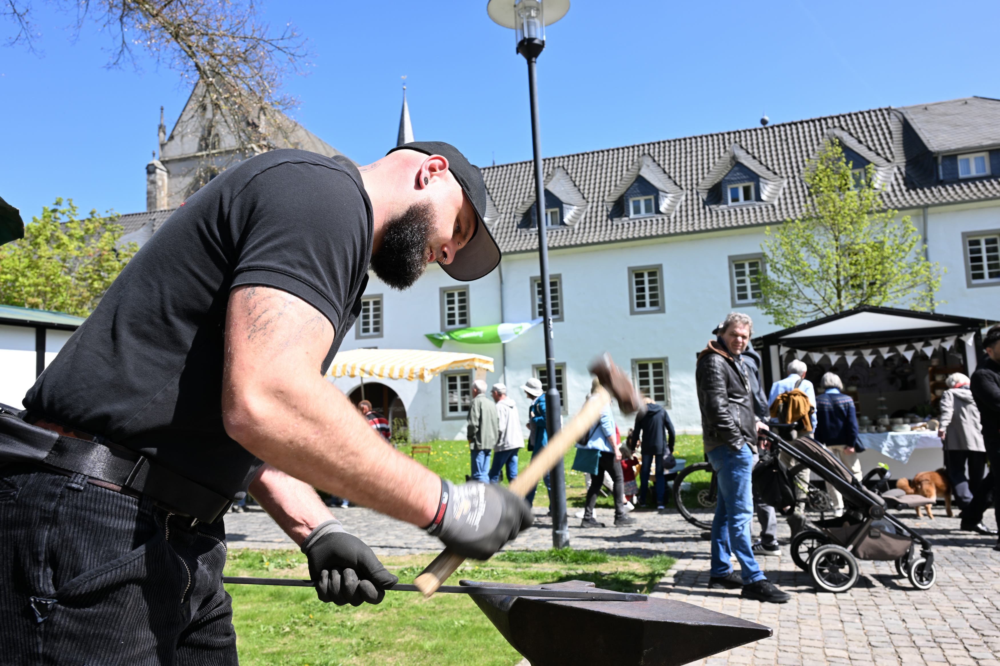 Ein Schmied hat mit einem Hammer auf ein Stück Eisen.