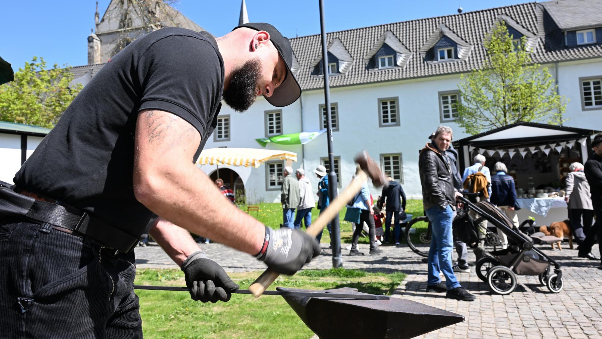 Ein Schmied hat mit einem Hammer auf ein Stück Eisen.