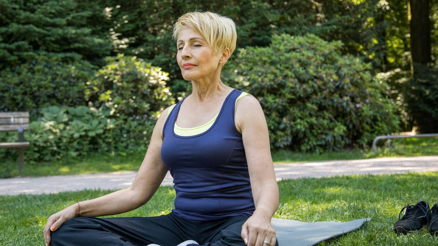 Frau macht Yoga-Übungen im Park