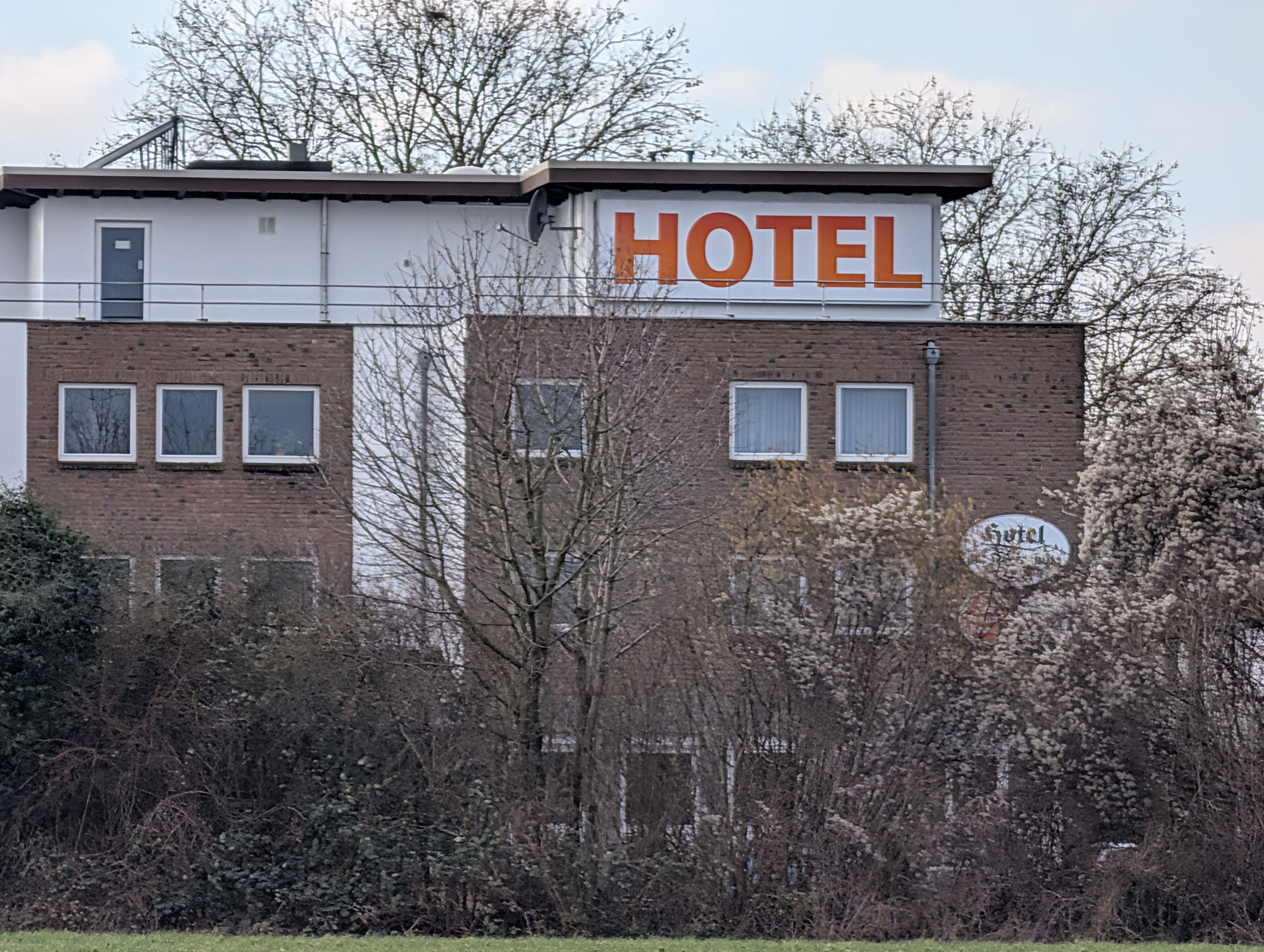Das Foto zeigt eine Außenaufnahme eines Gebäudes mit großem Schriftzug „Hotel“.