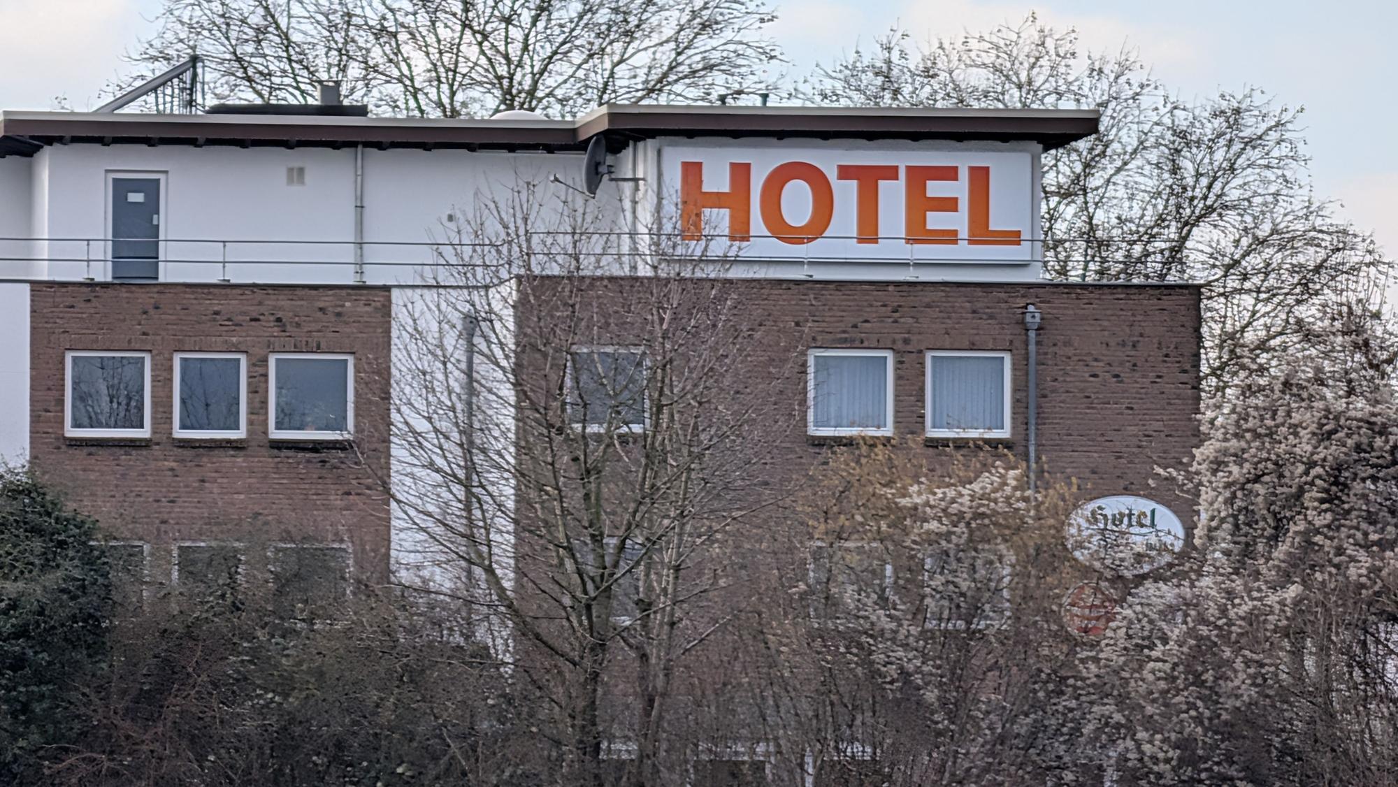 Das Foto zeigt eine Außenaufnahme eines Gebäudes mit großem Schriftzug „Hotel“.