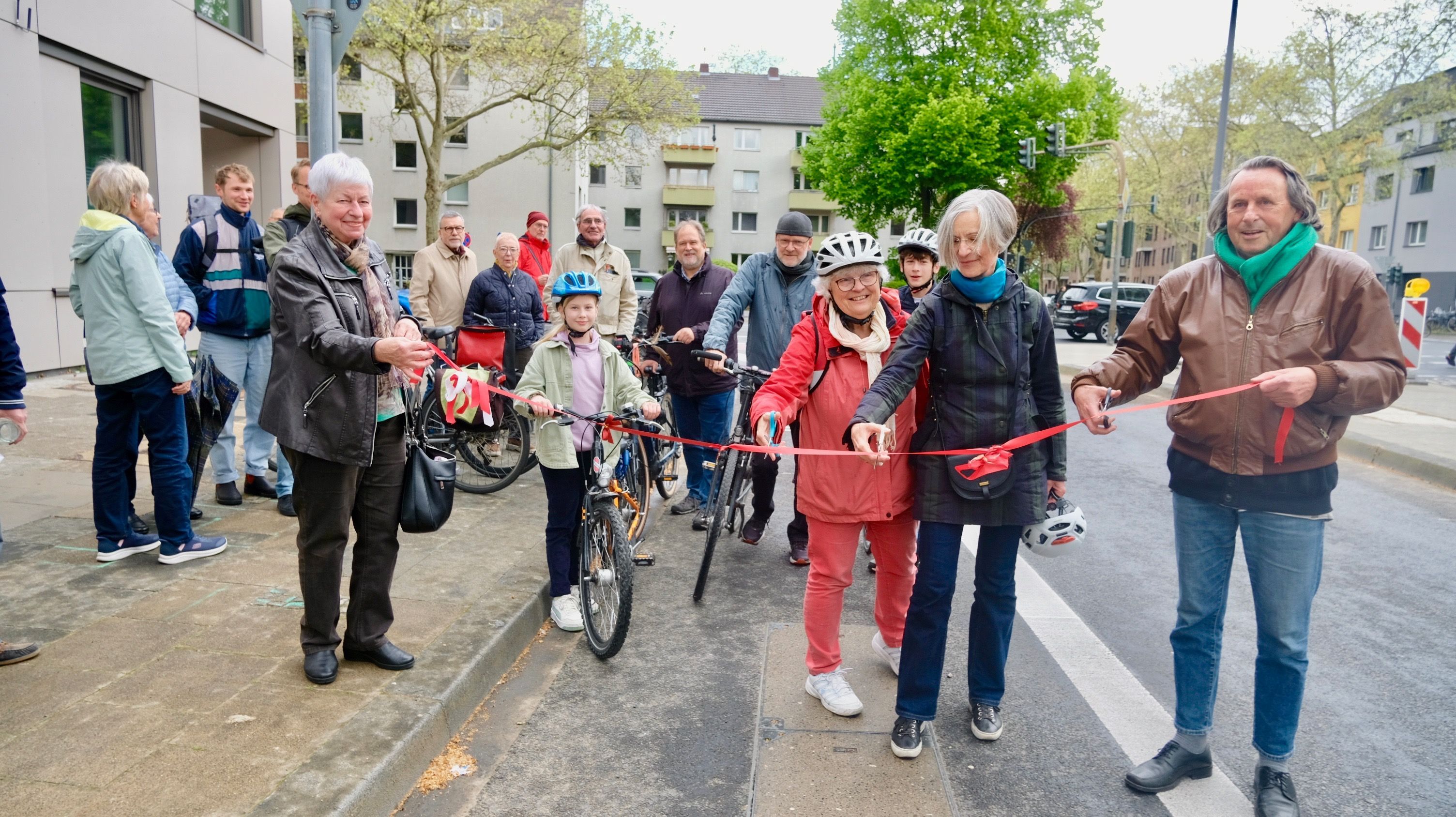 Hille Lammers (v.l.), die ehemalige Bezirksbürgermeisterin Cornelia Weitekamp (Grüne) und Bezirksbürgermeister Roland Schüler (Grüne) durchtrennen das rote Band. Barbara Albat (SPD, l.) hilft beim Halten.