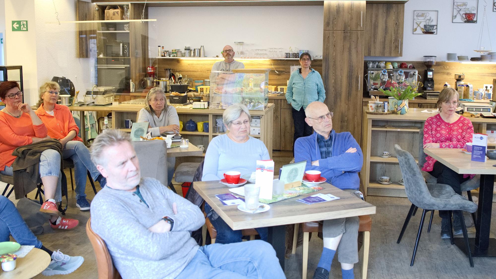 Besucher des Gesprächsabends zur Flutkatastrophe sitzen im Tee- und Kaffeehaus in Bad Münstereifel an Tischen.