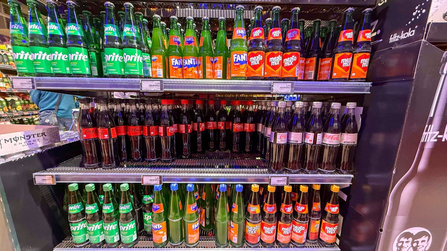 Regal mit Coca Cola Sprite Fanta Plastik Einwegflaschen im Getraenkemarkt zum Verkauf.