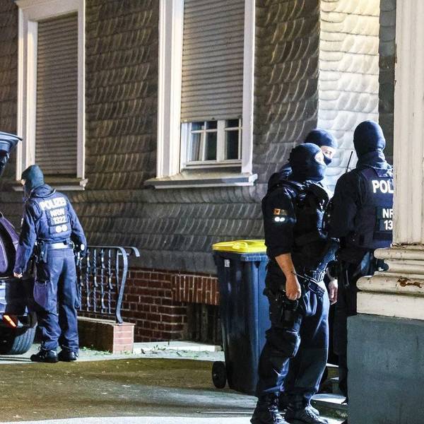 Das Bild zeigt vermummte Polizisten vor einem Haus.