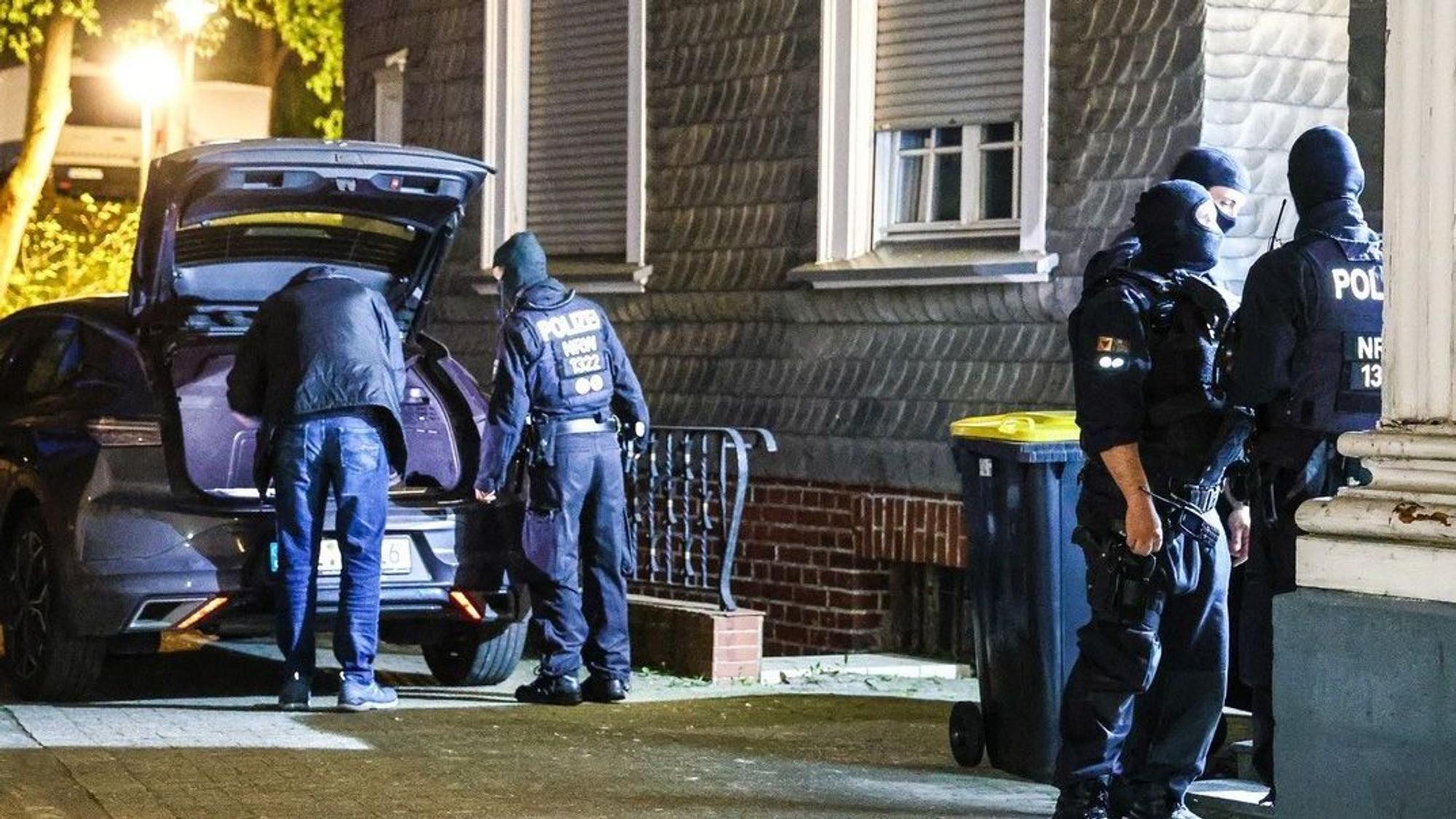 Das Bild zeigt vermummte Polizisten vor einem Haus.