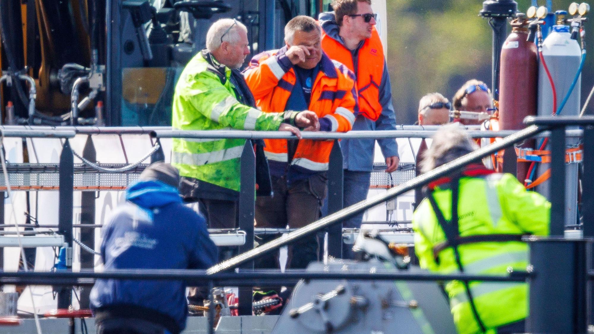 Tauchunternehmer Fred Babbel (M) feiert auf dem Transportschiff, nachdem der gestrandete Buckelwal vor der Insel Poel mit Gurten in den Lastkahn gezogen wurde.